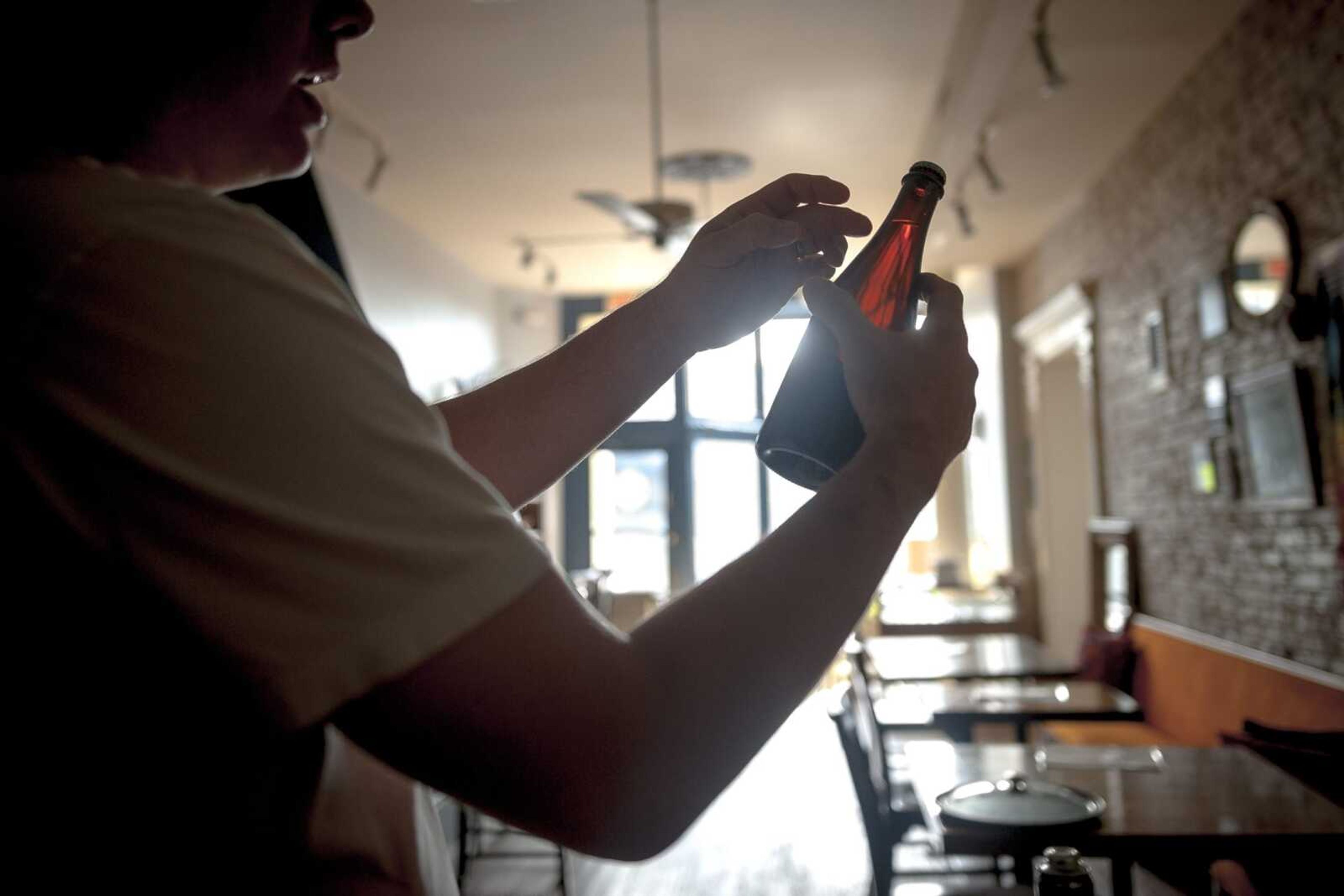 Brewer DeWayne Schaaf examines a bottle of beer Tuesday at Ebb and Flow Fermentations.