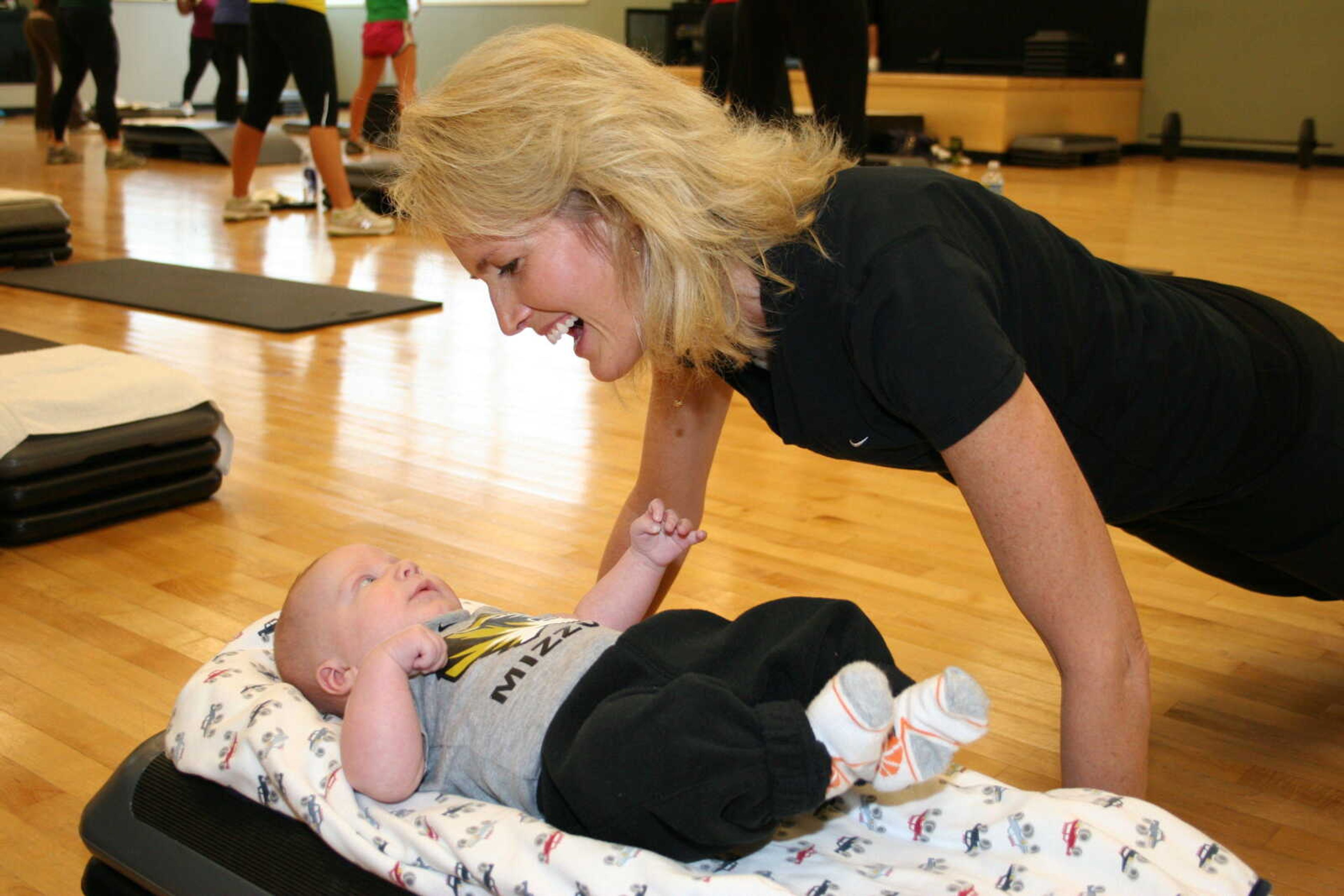 Alecia Robert smiles at her 3-month-old son, Braedyn, as she exercises at HealthPoint Fitness in Cape.