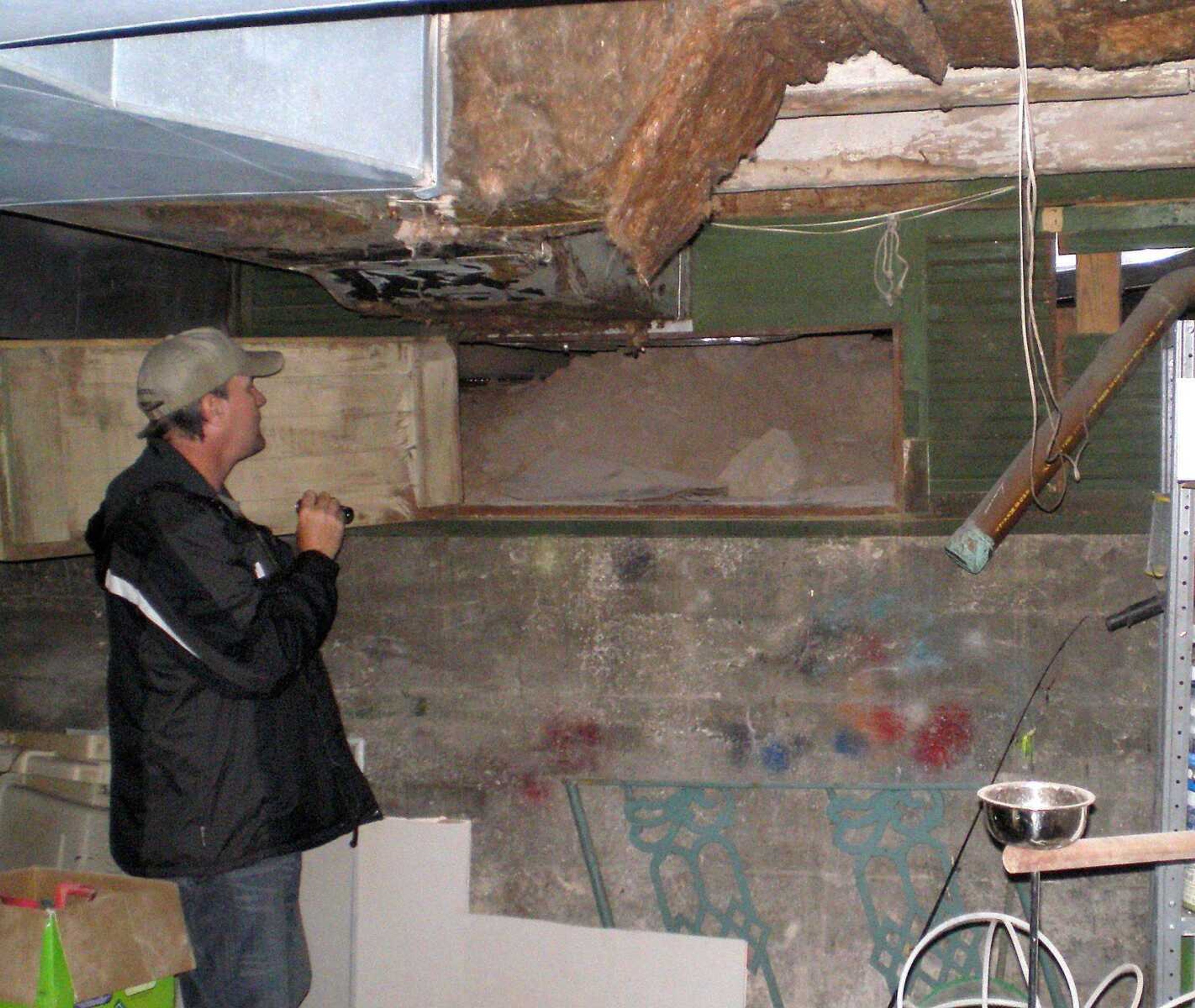 Mike Uelsmann inspects the entry to an alleged tunnel under the Minton House on Saturday. Uelsmann and Rich Newman of Paranormal Inc. came to investigate paranormal activity in the house on Washington Street in Cape Girardeau. (Katherine Webster)