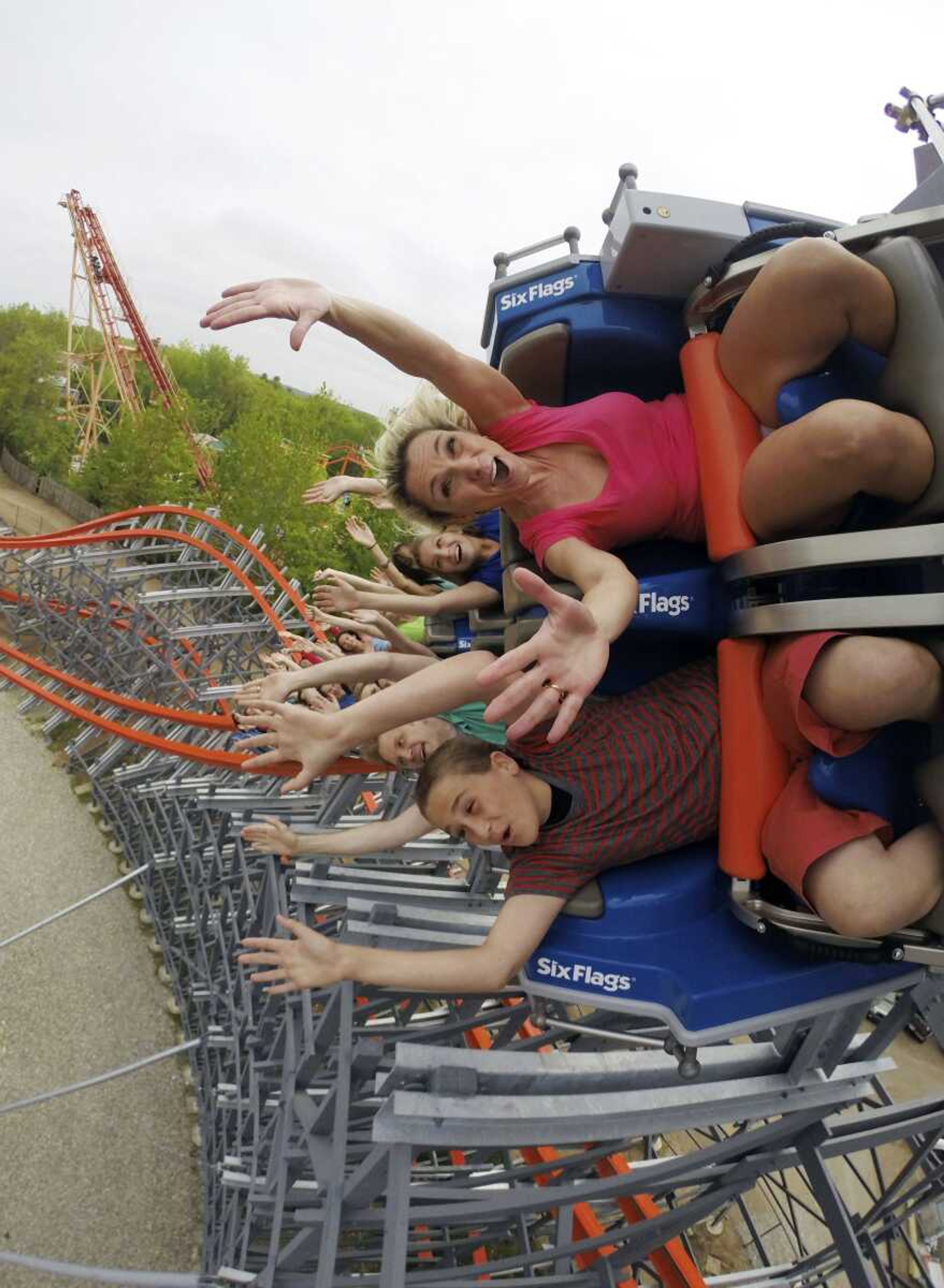 In this photo taken Saturday and provided by Six Flags New England, people ride the Wicked Cyclone in Agawam, Massachusetts. Several roller coasters are reopening this year after undergoing extensive rehabs. Six Flags New England transformed a traditional wooden coaster formerly known as the Cyclone into the Wicked Cyclone, a steel hybrid that's faster, steeper and twists riders through three inversions. (Six Flags New England)