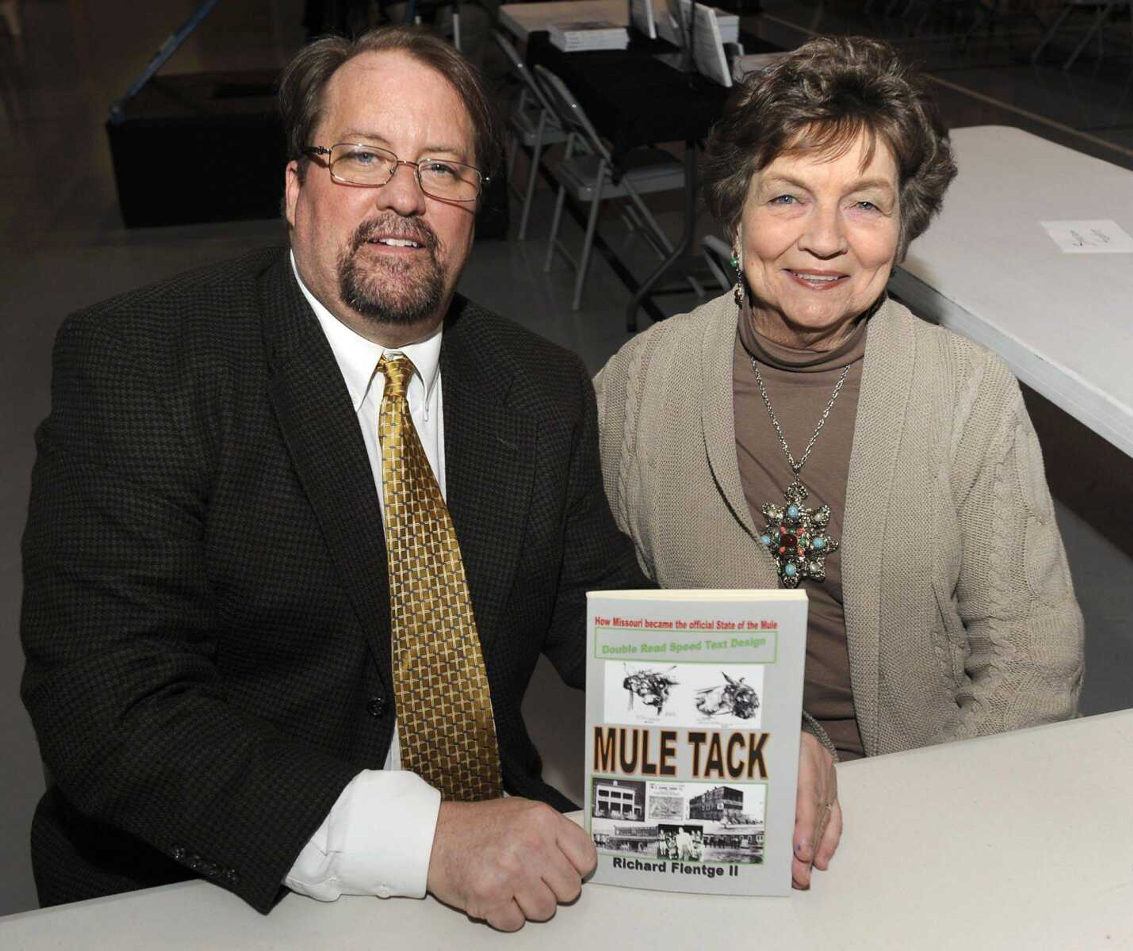 Richard Flentge II holds his book about the Missouri Mule with Lois Woodford on March 22. Woodward and her late husband, Charles, were instrumental in leading a campaign to have the Missouri Mule adopted as the state animal. (Fred Lynch)