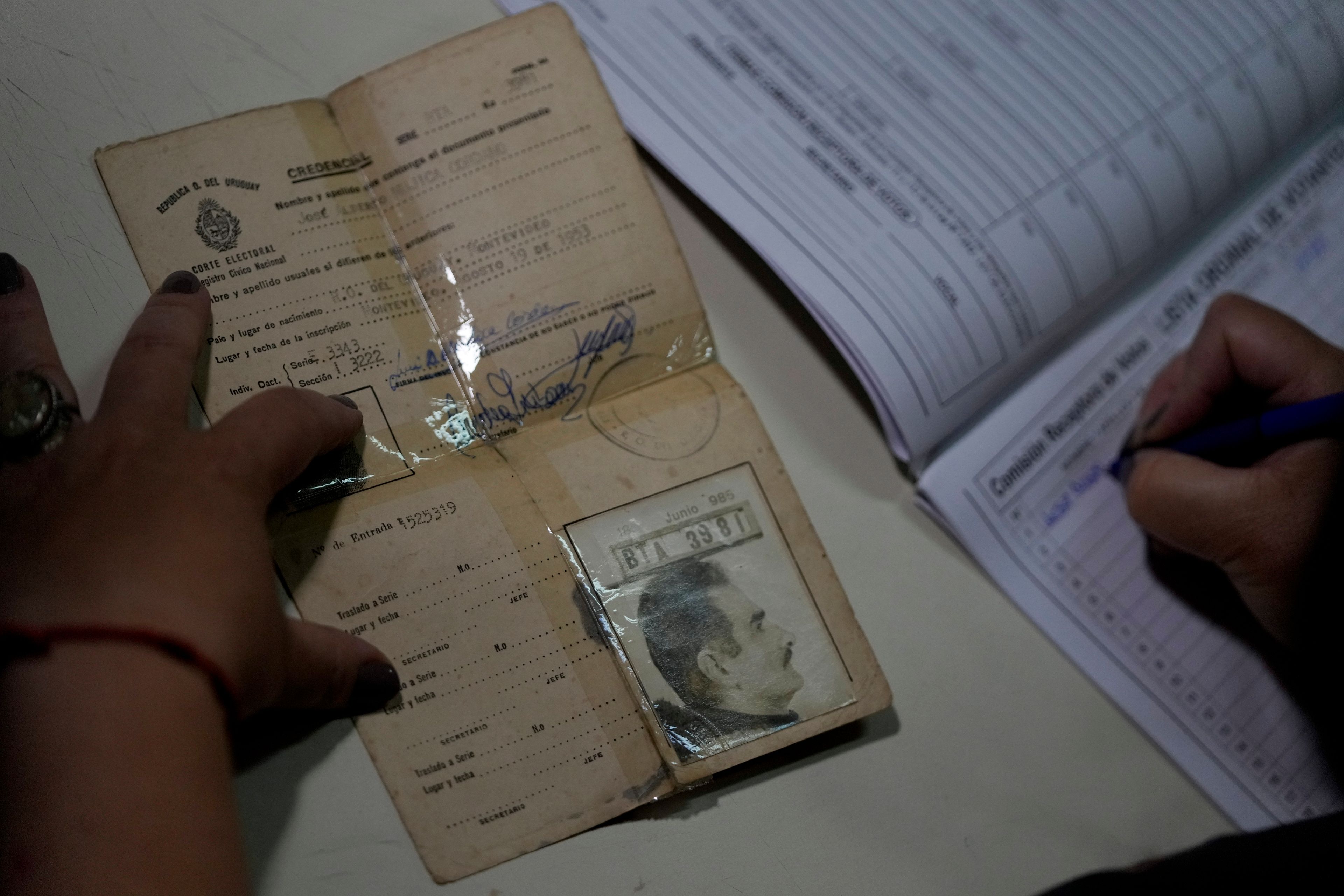 An election worker holds former Uruguayan President Jose "Pepe" Mujica's document before he votes at a polling station during general elections in Montevideo, Uruguay, Sunday, Oct. 27, 2024. (AP Photo/Natacha Pisarenko)