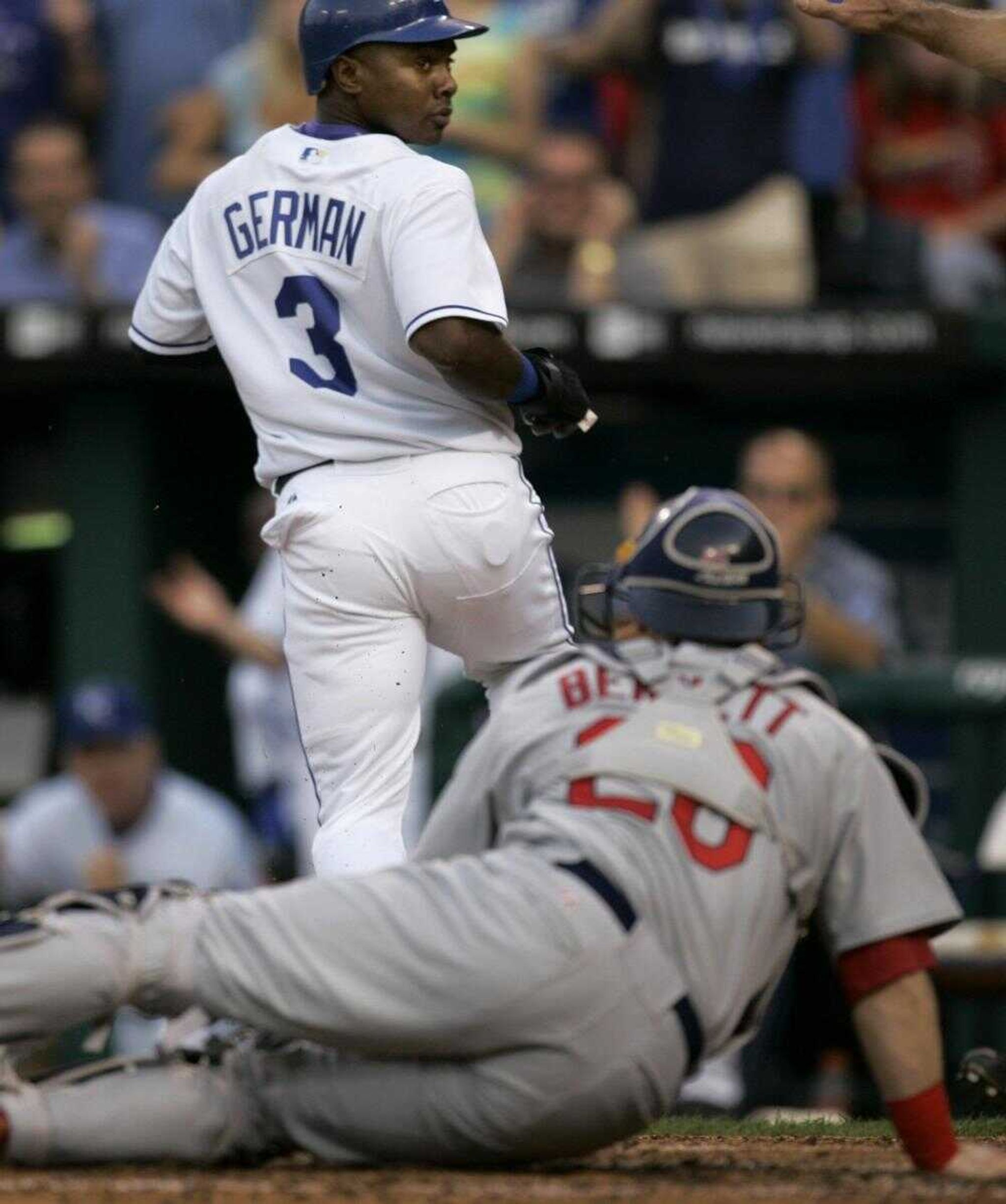 Royals baserunner Esteban German looked back at Cardinals catcher Gary Bennett after beating the tag to score on a double during the first inning Tuesday in Kansas City, Mo.