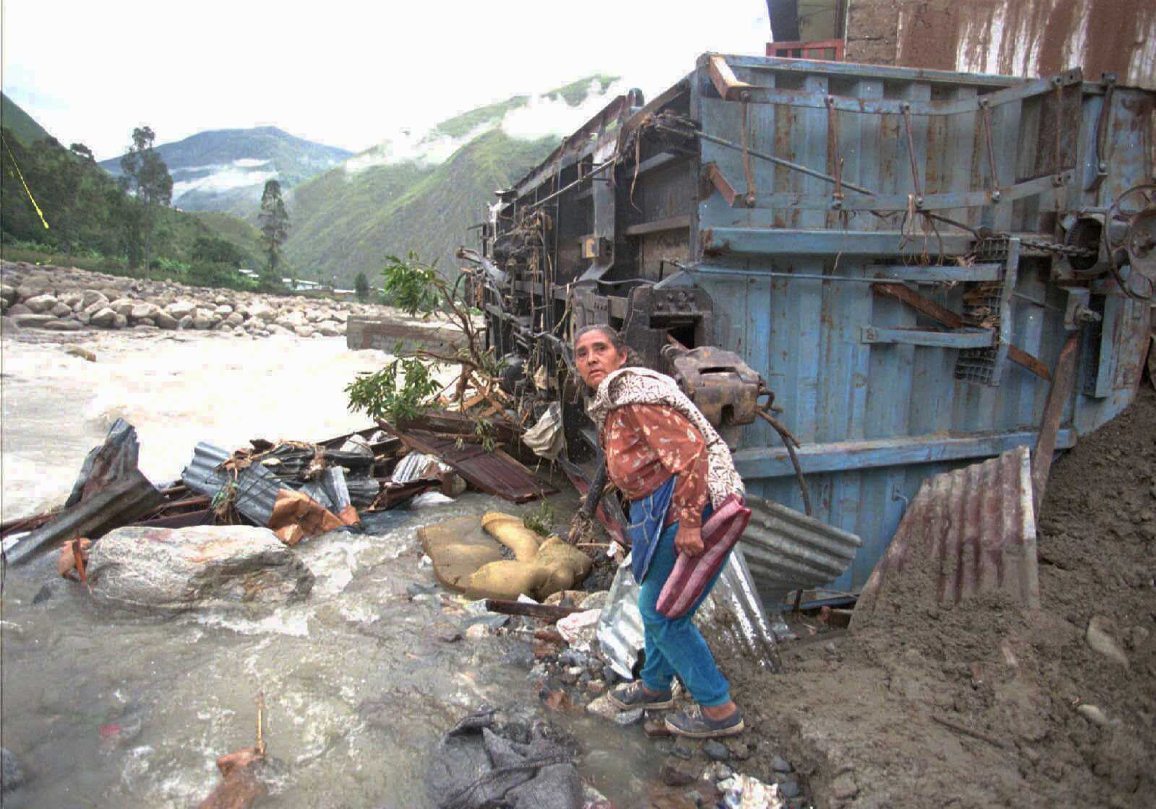 A woman sifts through rubble near her destroyed home in January 1998 after much of the town of Santa Teresa in Cuzco, Peru, was destroyed by a mudslide brought on by persistent rains attributed to El Nino. (Oscar Paredes ~ Associated Press)