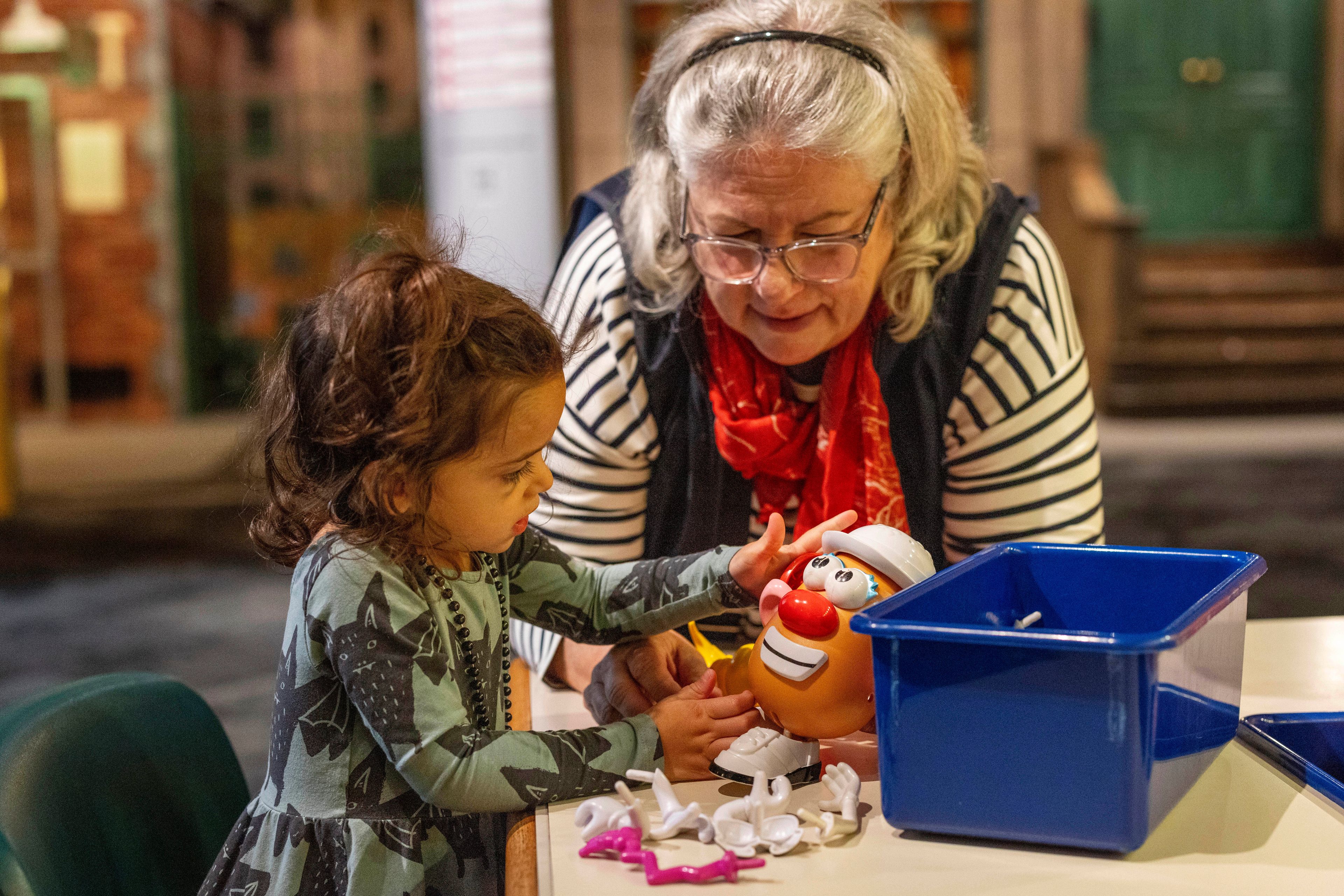 Suellen Sues puts together a Potato Head with her granddaughter, Isla, 2, while visiting The Strong National Museum of Play, Tuesday, Oct. 15, 2024, in Rochester, N.Y. (AP Photo/Lauren Petracca)