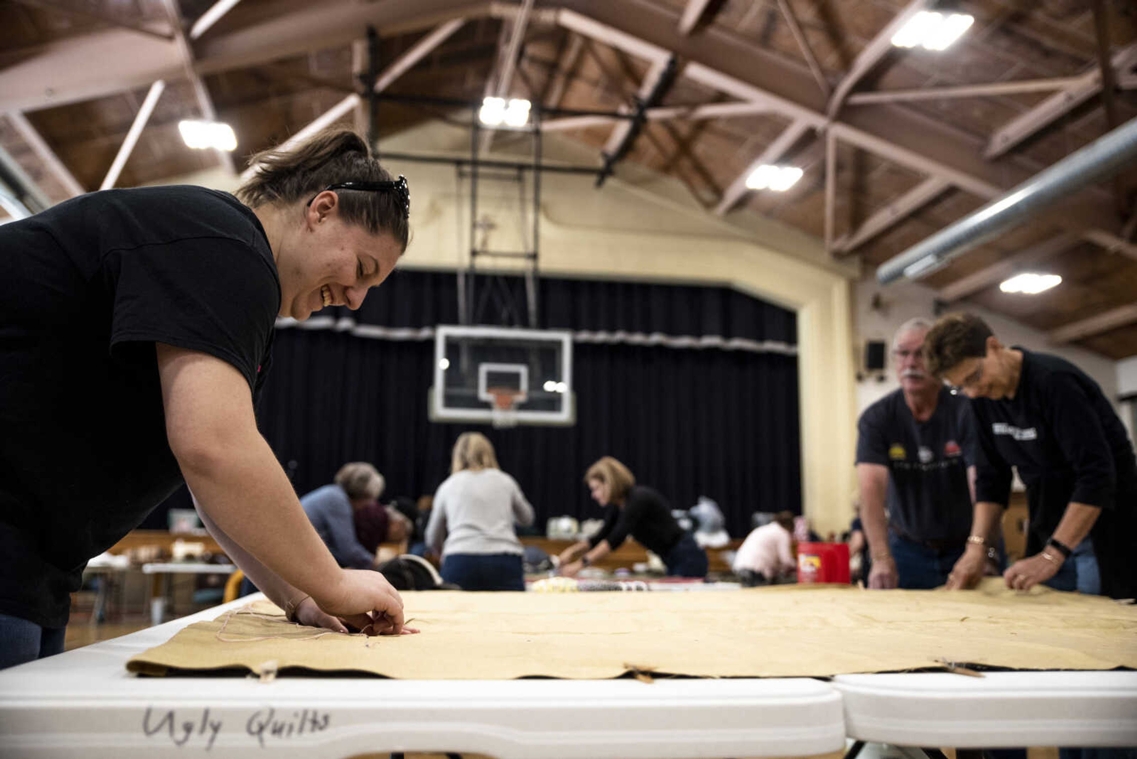 Amanda Lively, left, tacks a quilt during the Ugly Quilt Weekend at St. Vincent de Paul Parish Sunday, Oct. 28, 2018, in Cape Girardeau.