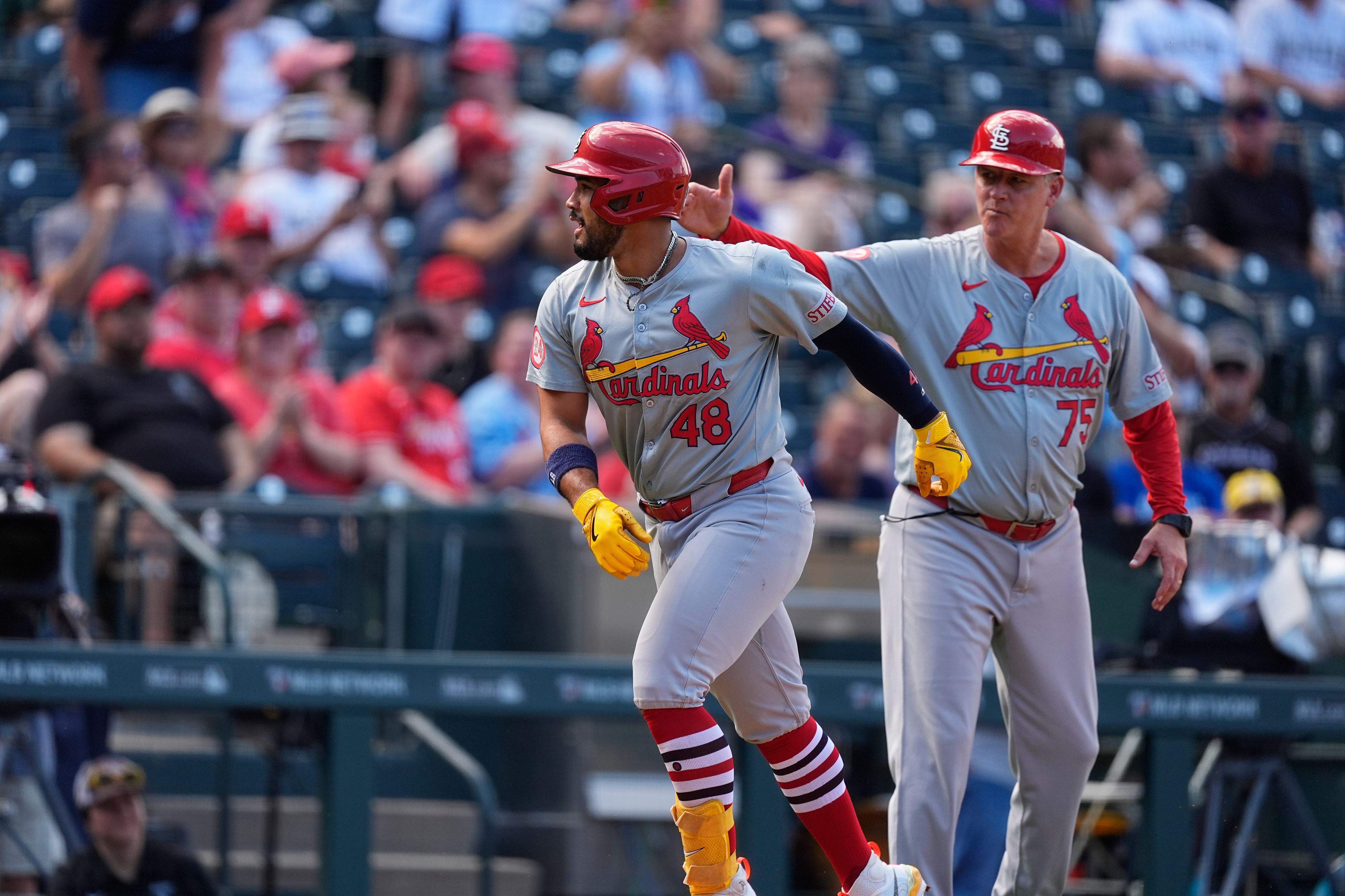 St. Louis Cardinals' Iván Herrera, left, is congratulated by third base coach Ron Warner, right, while circling the bases after hitting a solo home run in the fifth inning of a baseball game against the Colorado Rockies, Thursday, Sept. 26, 2024, in Denver. (AP Photo/David Zalubowski)