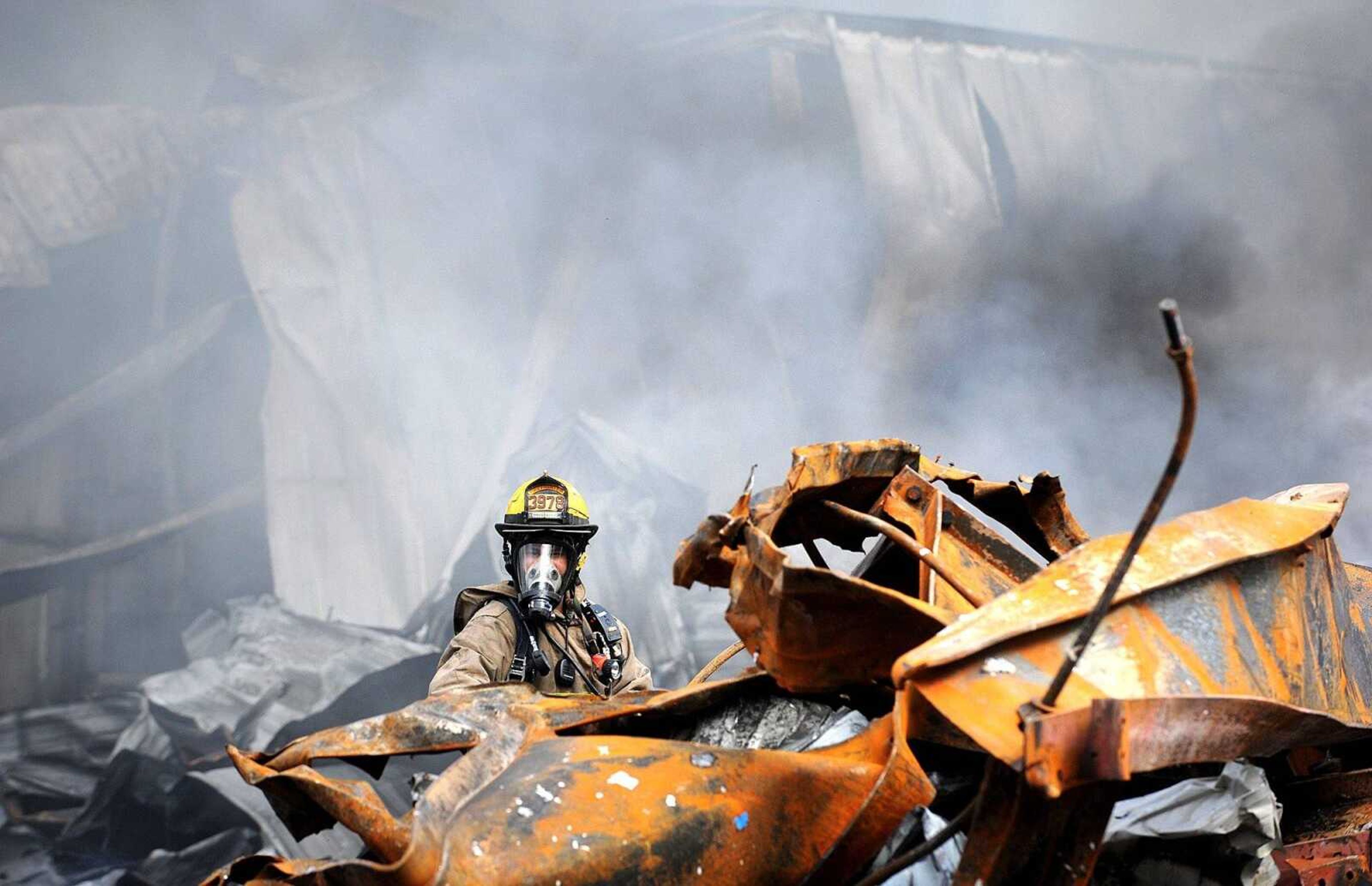 David Goehman with the East County Fire Protection District works to put out hot spots at the Missouri Plastics plant Friday morning, Oct. 4, 2013, in Jackson. The approximately 100,000-square-foot recycling plant caught fire around 10 p.m. Thursday. Every fire department in Cape Girardeau County was dispatched to battle the blaze. (Laura Simon)