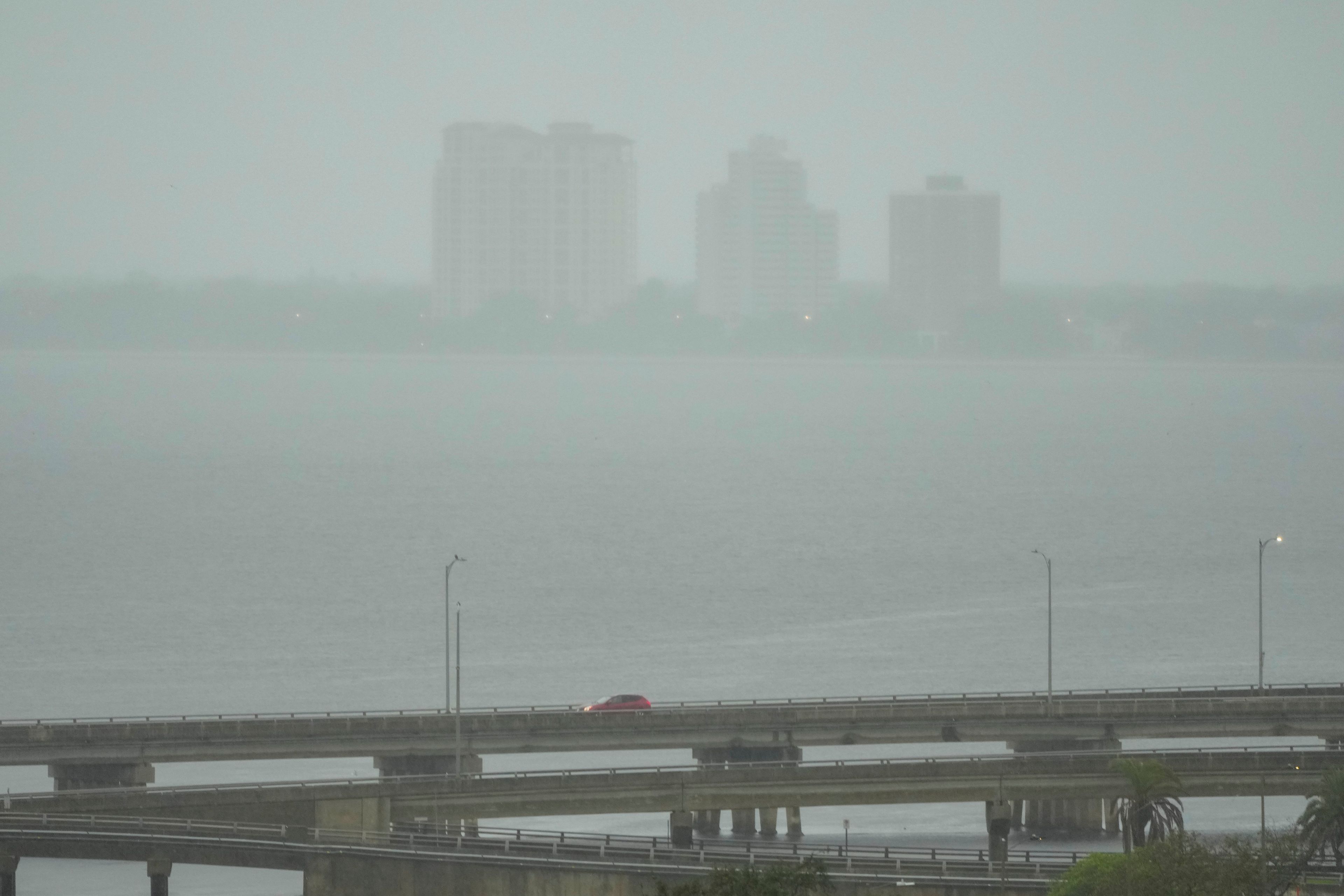 A vehicle crosses a bridge as rain begins to fall ahead of the arrival of Hurricane Milton, Wednesday, Oct. 9, 2024, in Tampa, Fla. (AP Photo/Julio Cortez)