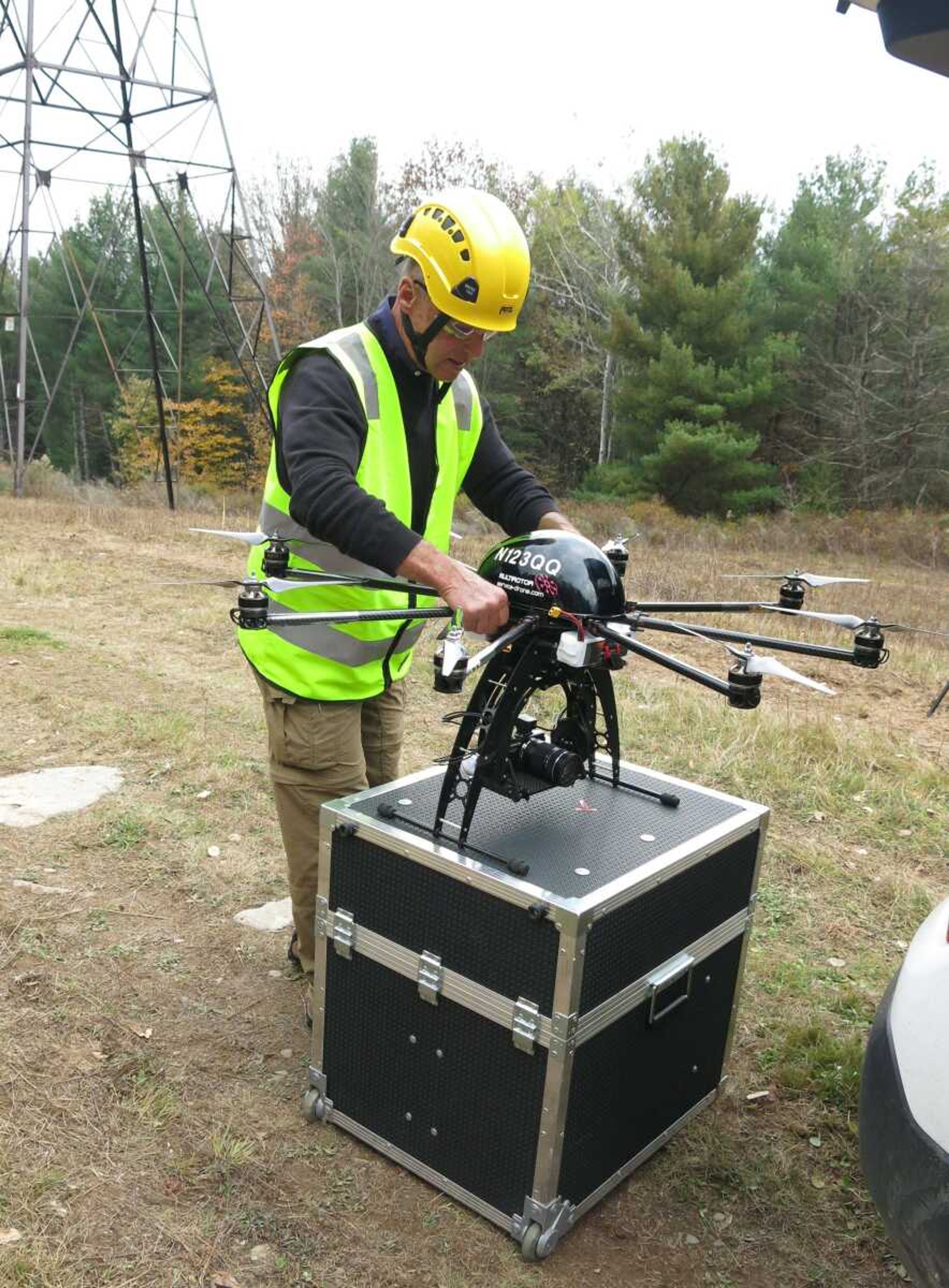 Bernd Lutz, CEO of Colorado-based bizUAS Corp., which provides drone services for utilities and other industries, prepares to demonstrate the use of a Cyberhawk octocopter drone for power line inspections at a New York Power Authority site Oct. 21 near Blenheim, New York. (Mary Esch ~ Associated Press)