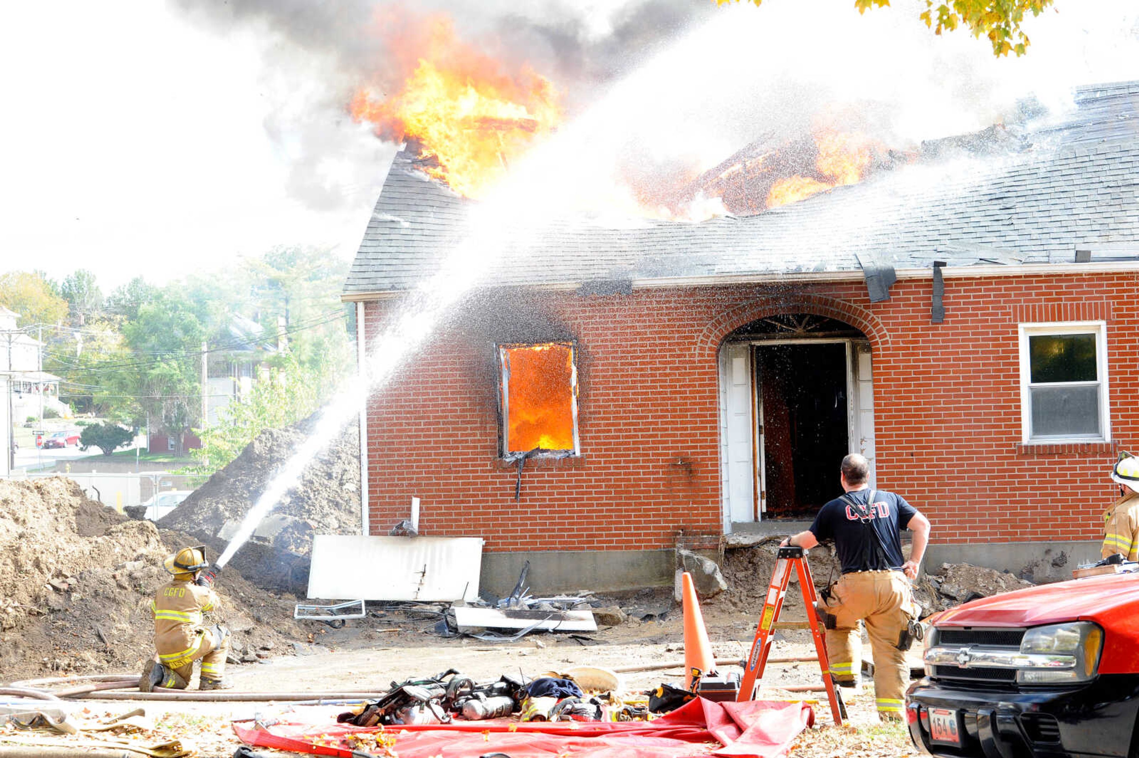 First- and second-year firefighters spray the structure at 222 N. Middle St. with a hose at the live burn exercise held by the Cape Girardeau Fire Department on Friday, Oct. 23, 2020.