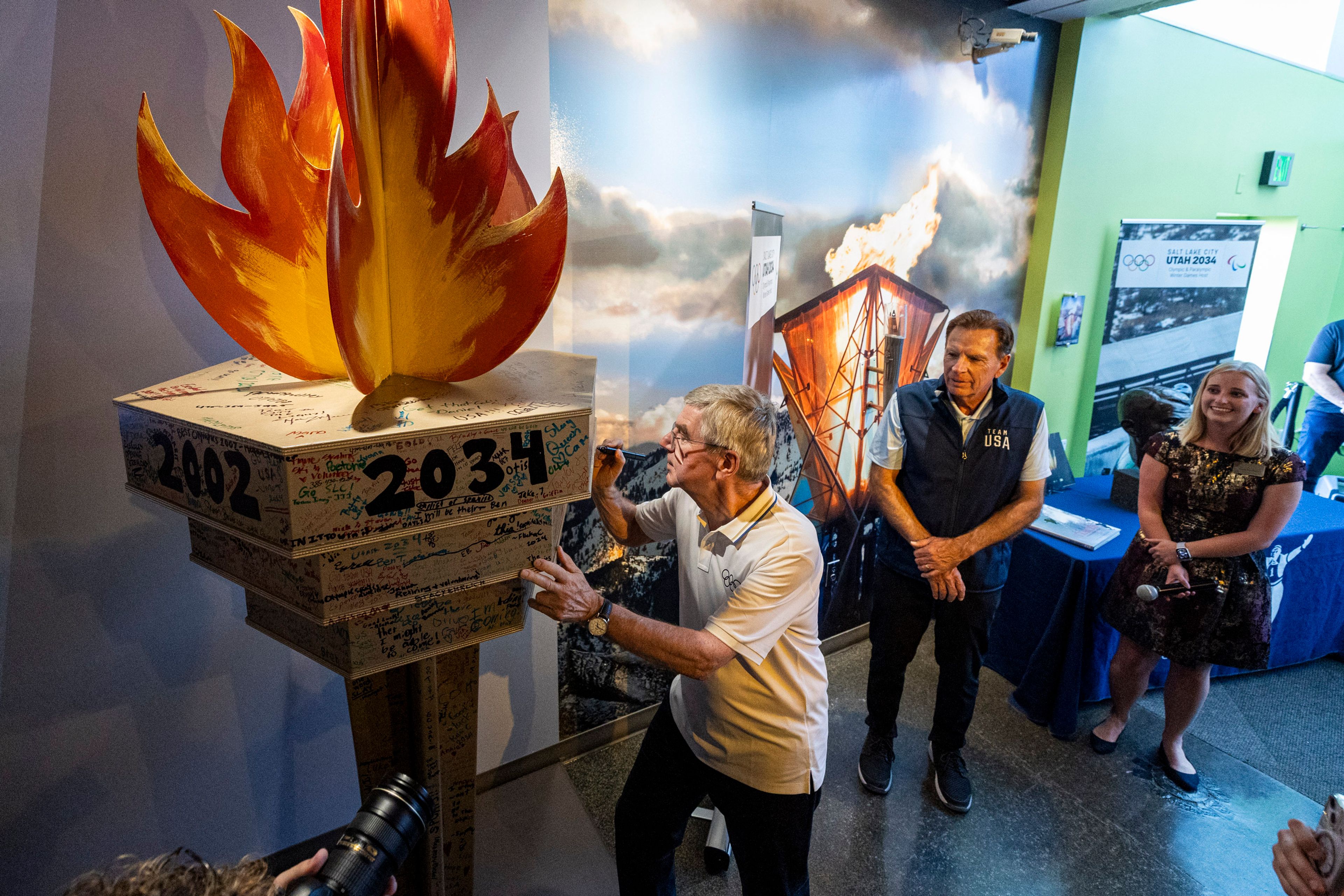 International Olympic Committee President Thomas Bach, center, signs the 2034 torch display at the 2002 Olympic and Paralympic Museum within Utah Olympic Park in Park City, Utah, Saturday, Sept. 28. 2024. (Isaac Hale/The Deseret News via AP)