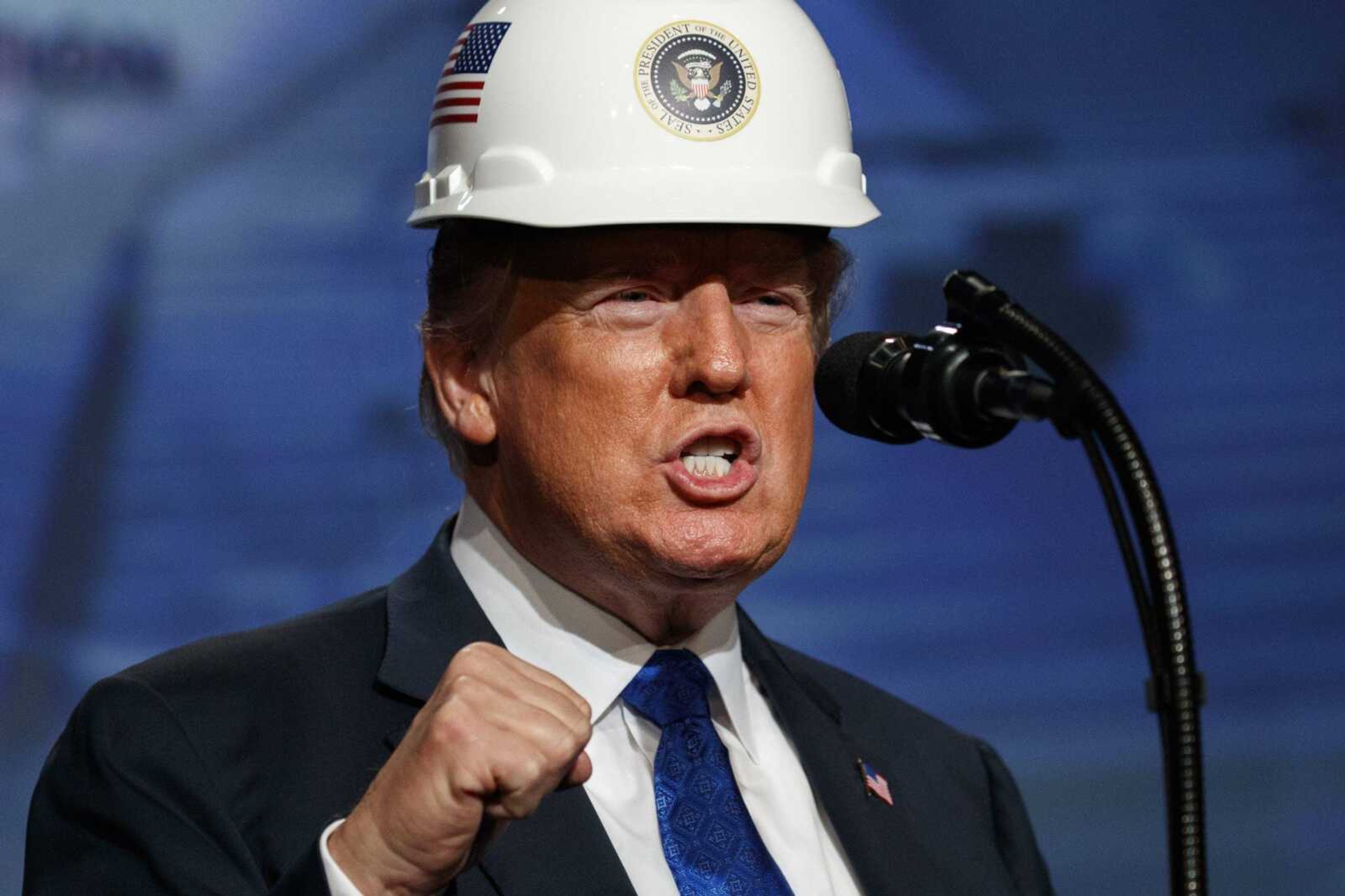 President Donald Trump pumps his fist after putting on a hard hat given to him before speaking Tuesday to the National Electrical Contractors Association Convention at the Pennsylvania Convention Center in Philadelphia.