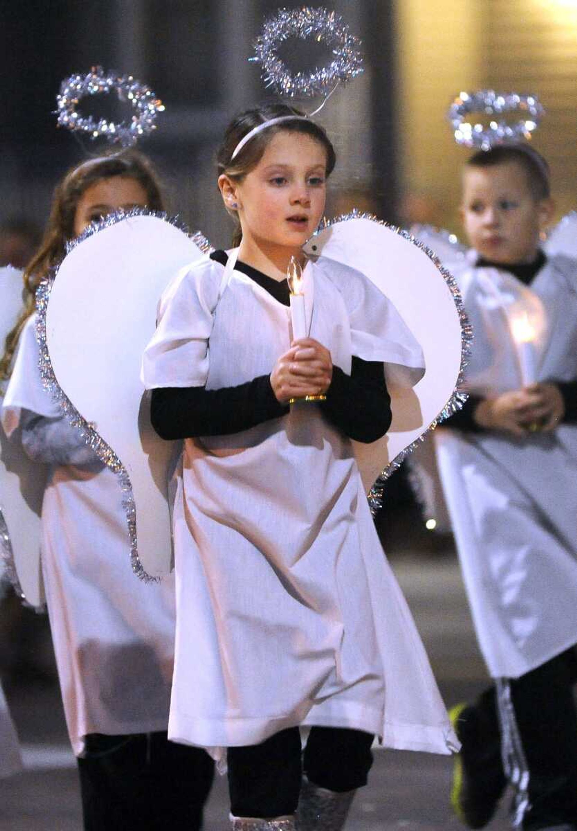 An angel follows a float from Trinity Lutheran School at the Christmas Parade of Lights Sunday, Nov. 30, 2014 on Broadway in Cape Girardeau.