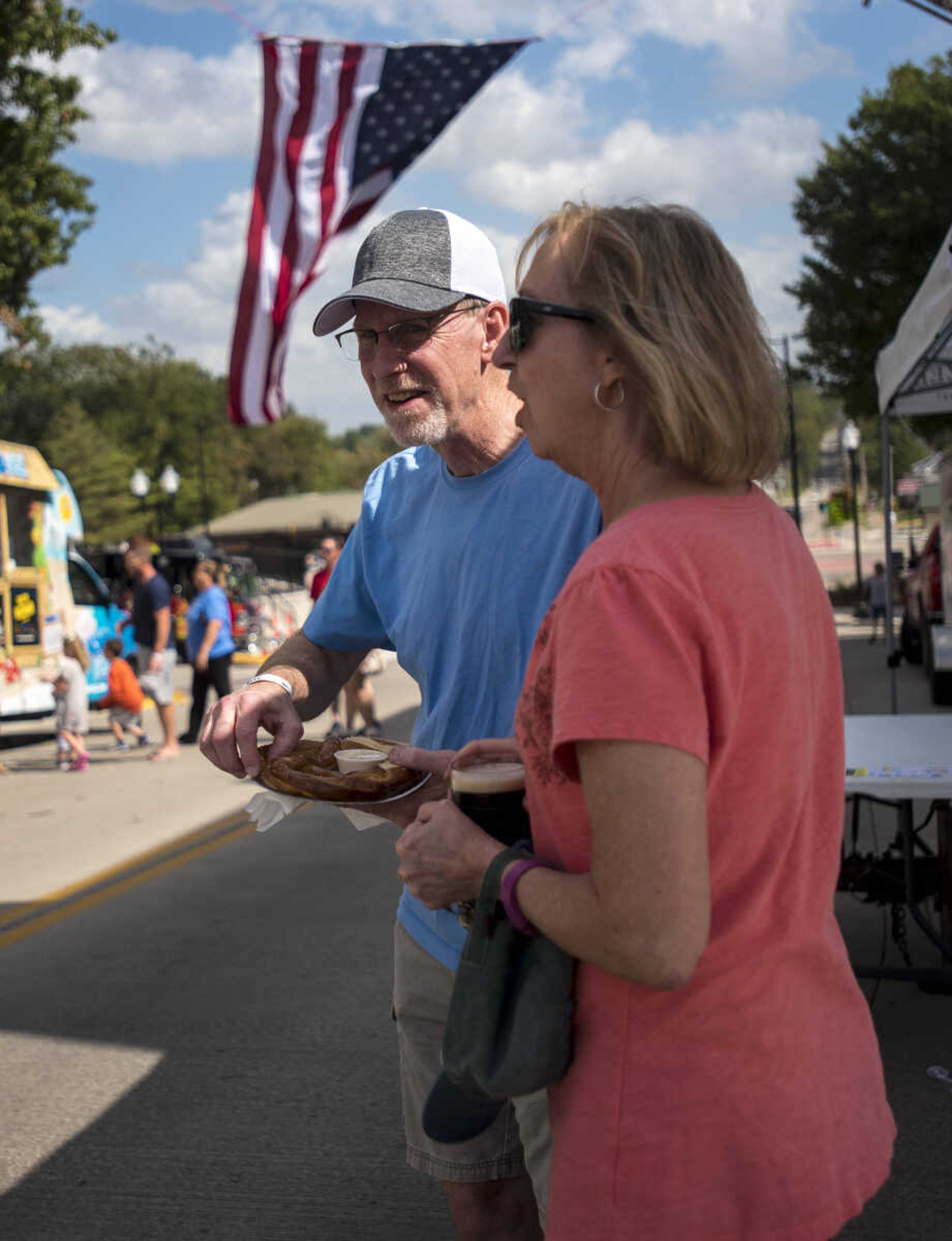 Mike and Carol Tenholder walk away a giant pretzel at the Uptown Jackson Oktoberfest, Saturday, October 7, 2017.