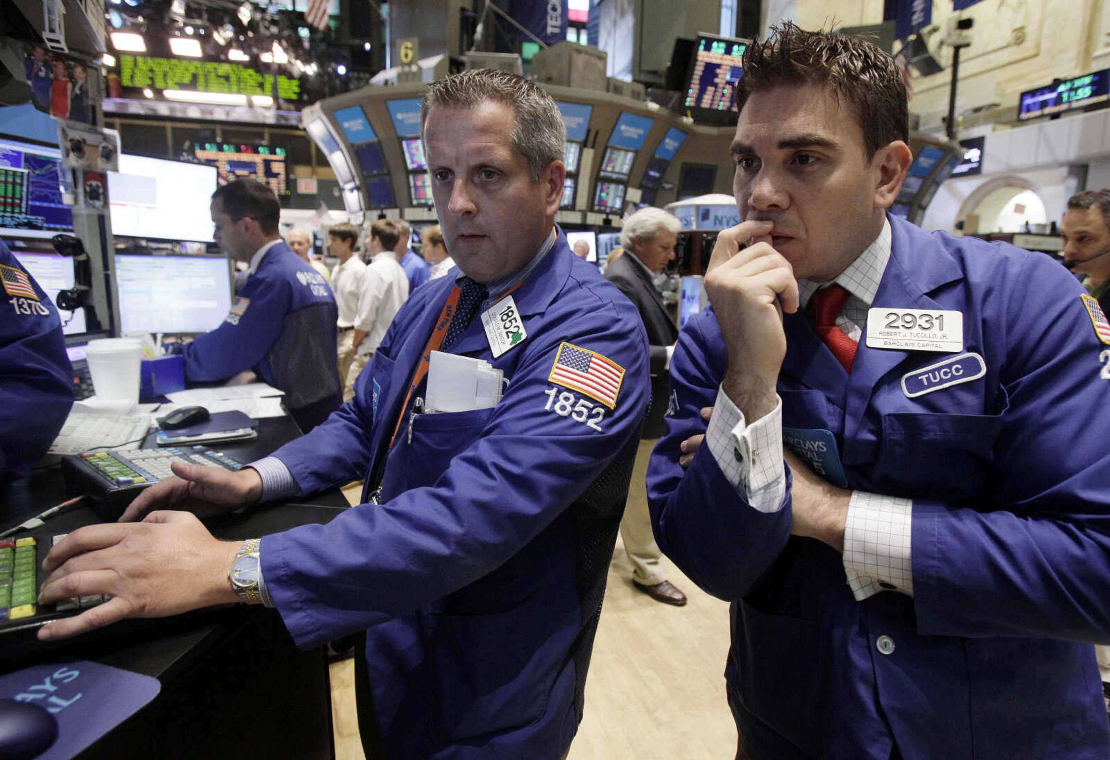 Specialists Donald Vaneck, center, and Robert Tuccillo work on the floor of the New York Stock Exchange Tuesday, Aug. 9, 2011. (AP Photo/Richard Drew)