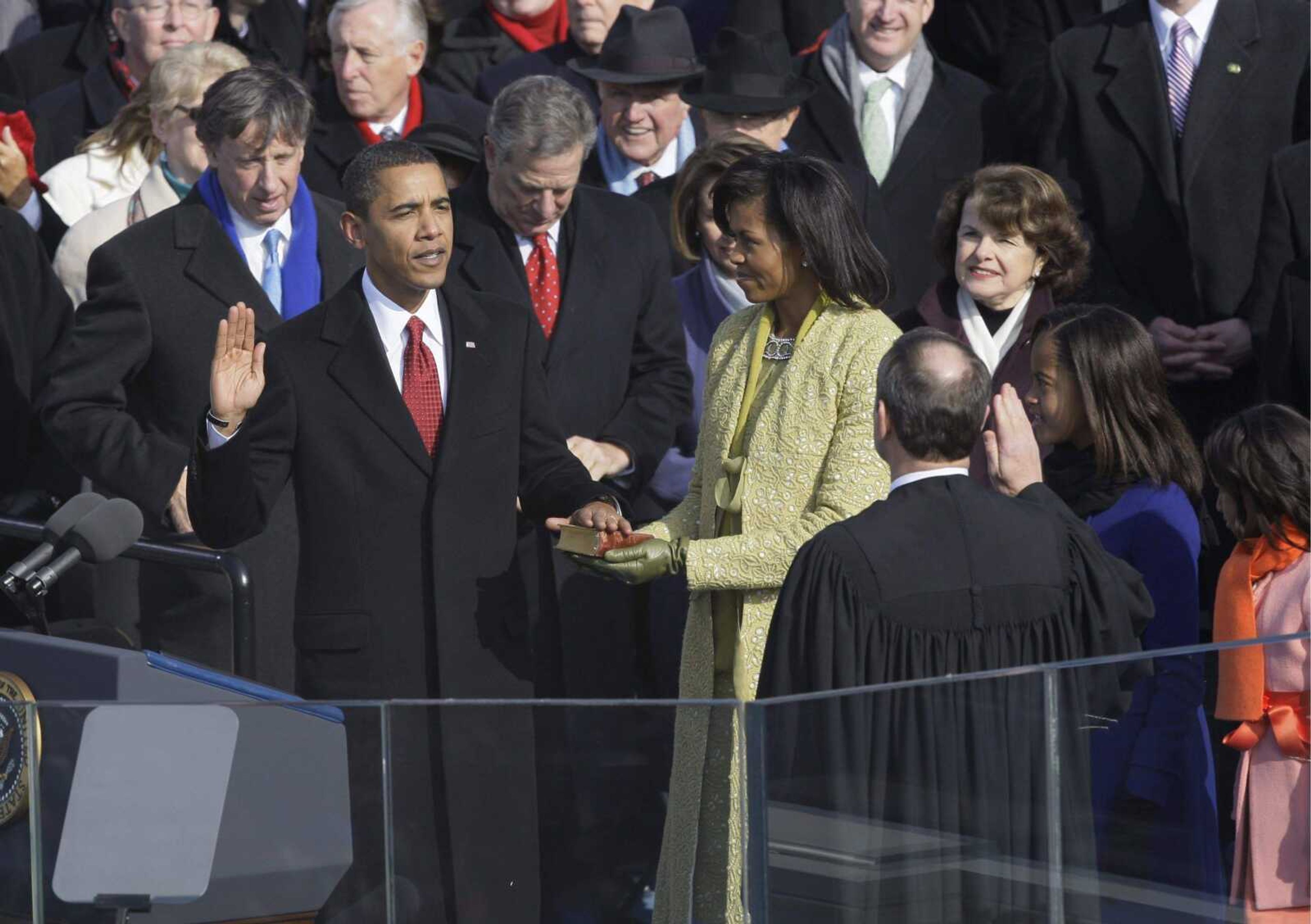 Barack Obama, left, joined by his wife Michelle, second from left, and daughters Sasha, third from left, and Malia, takes the oath of office from Chief Justice John Roberts to become the 44th president of the United States at the U.S. Capitol in Washington, Tuesday, Jan. 20, 2009. (AP Photo/Elise Amendola)