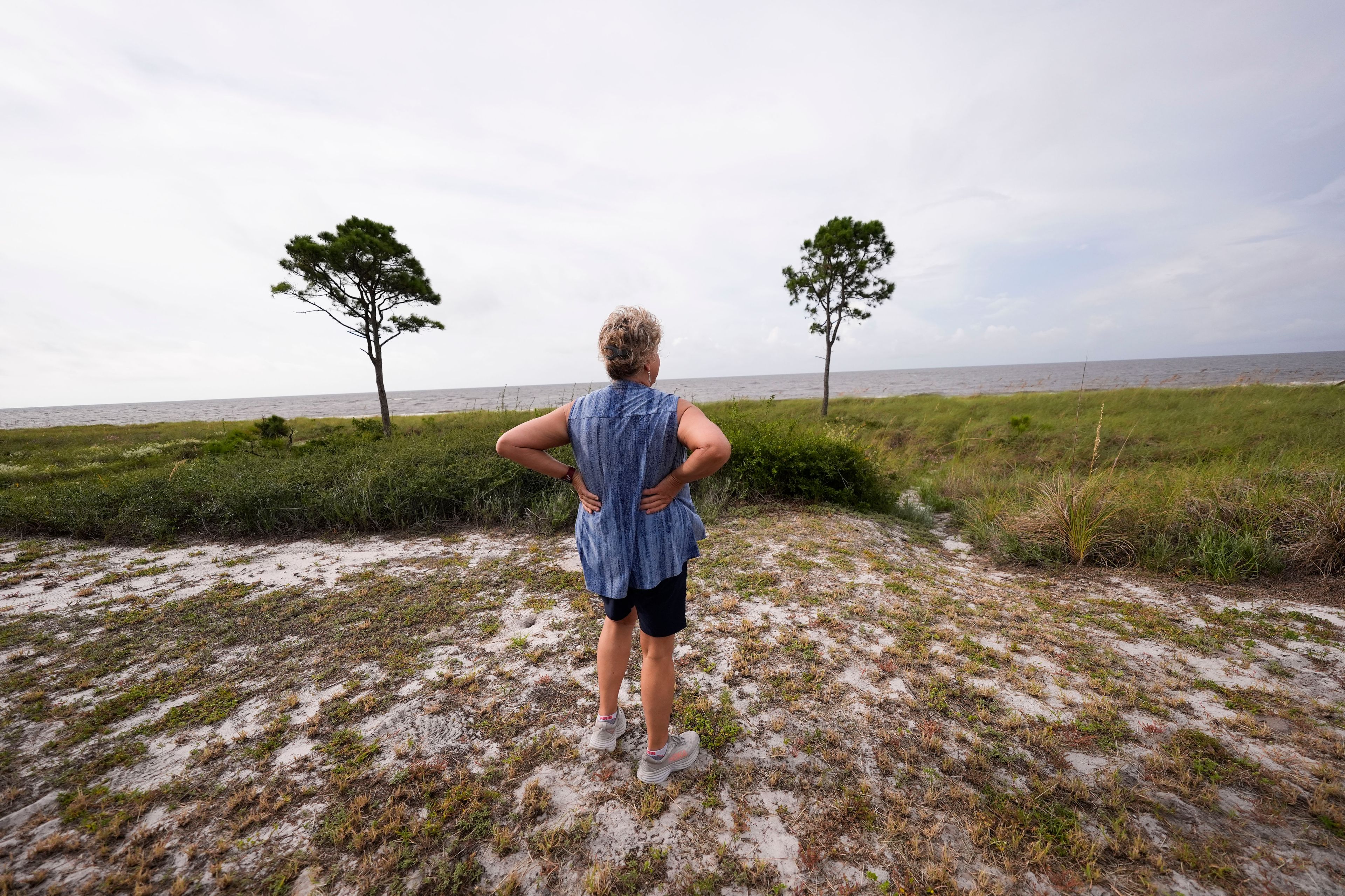 Paulette McLin takes in the scene outside their summer home ahead of Hurricane Helene, expected to make landfall Thursday evening, in Alligator Point, Fla., Wednesday, Sept. 25, 2024. (AP Photo/Gerald Herbert)