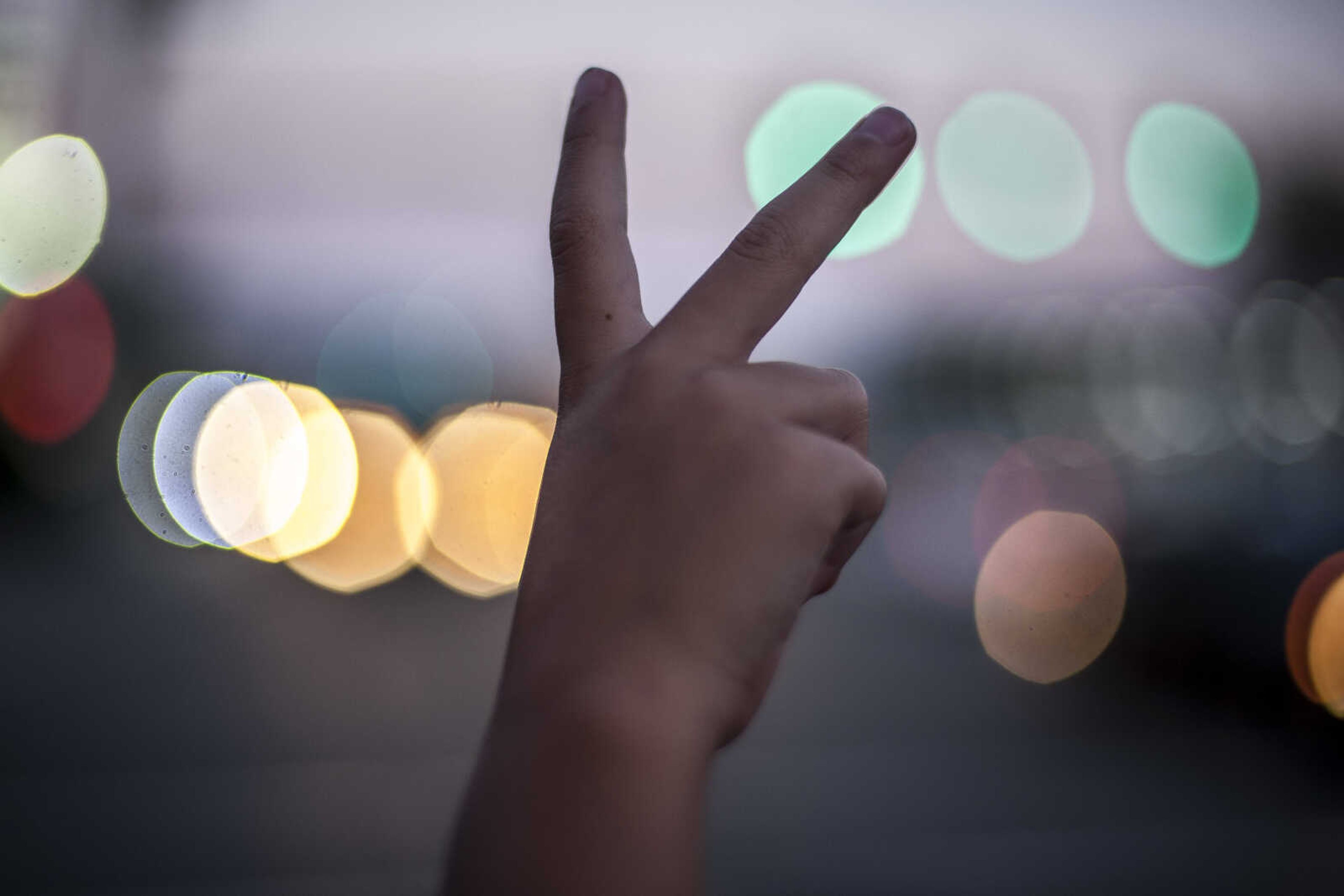 Willow Rieger, 6, holds up a peace sign to passing traffic while demonstrating with dozens of other protesters Friday, May 17, 2019, at Capaha Park's Freedom Corner in Cape Girardeau.  The demonstration was held to denounce controversial U.S. immigration policy as well as subpar conditions in migrant detention centers which have become a cultural flashpoint in recent weeks.