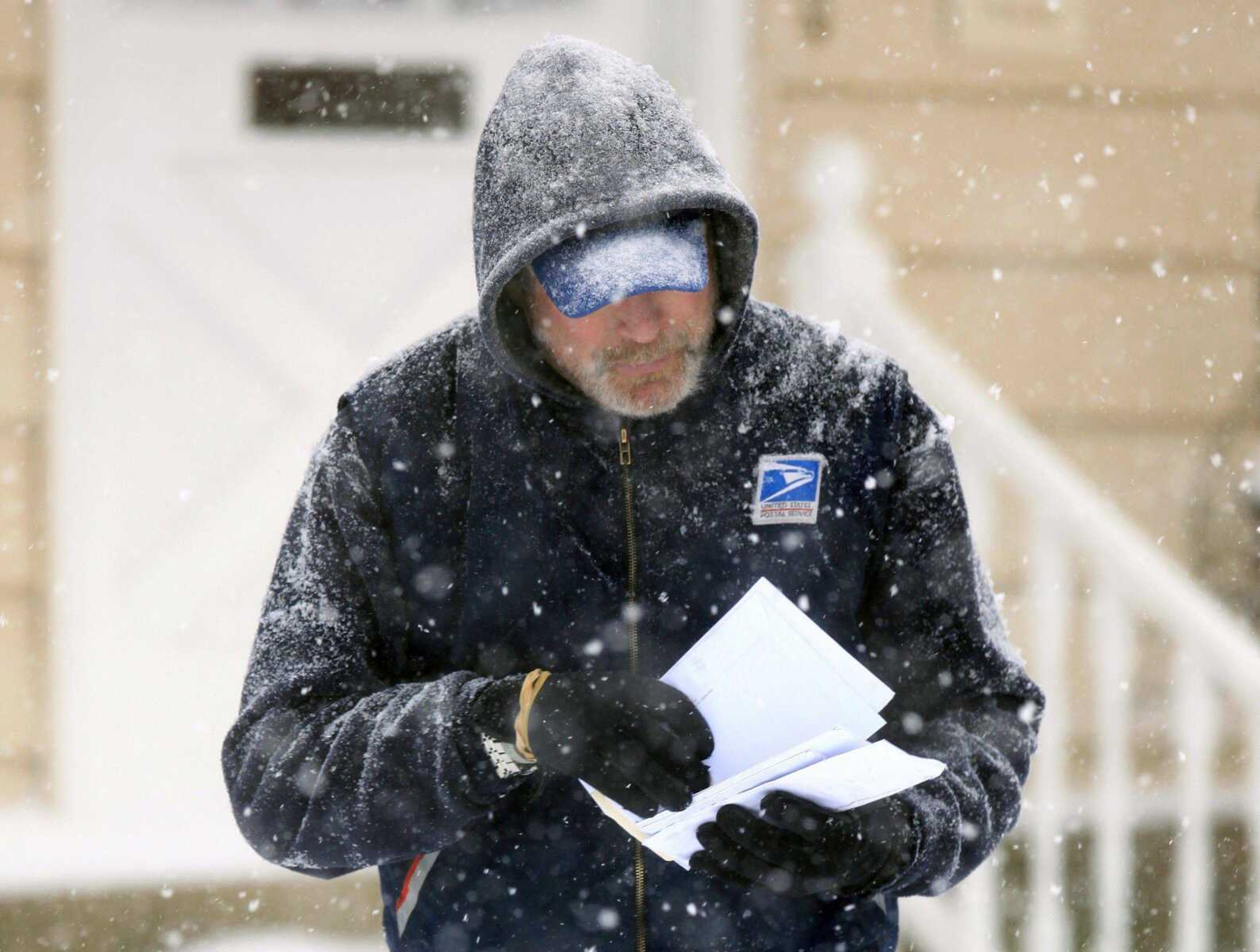 FILE - In this Saturday, Dec. 19, 2009 file photo, U. S. Post Office letter carrier Tim Bell delivers the mail during a snow storm in Havertown, Pa. The U.S. Postal Service is increasing the pressure for dropping Saturday home delivery as it seeks to fend off massive financial losses.(AP Photo/Jacqueline Larma, file)