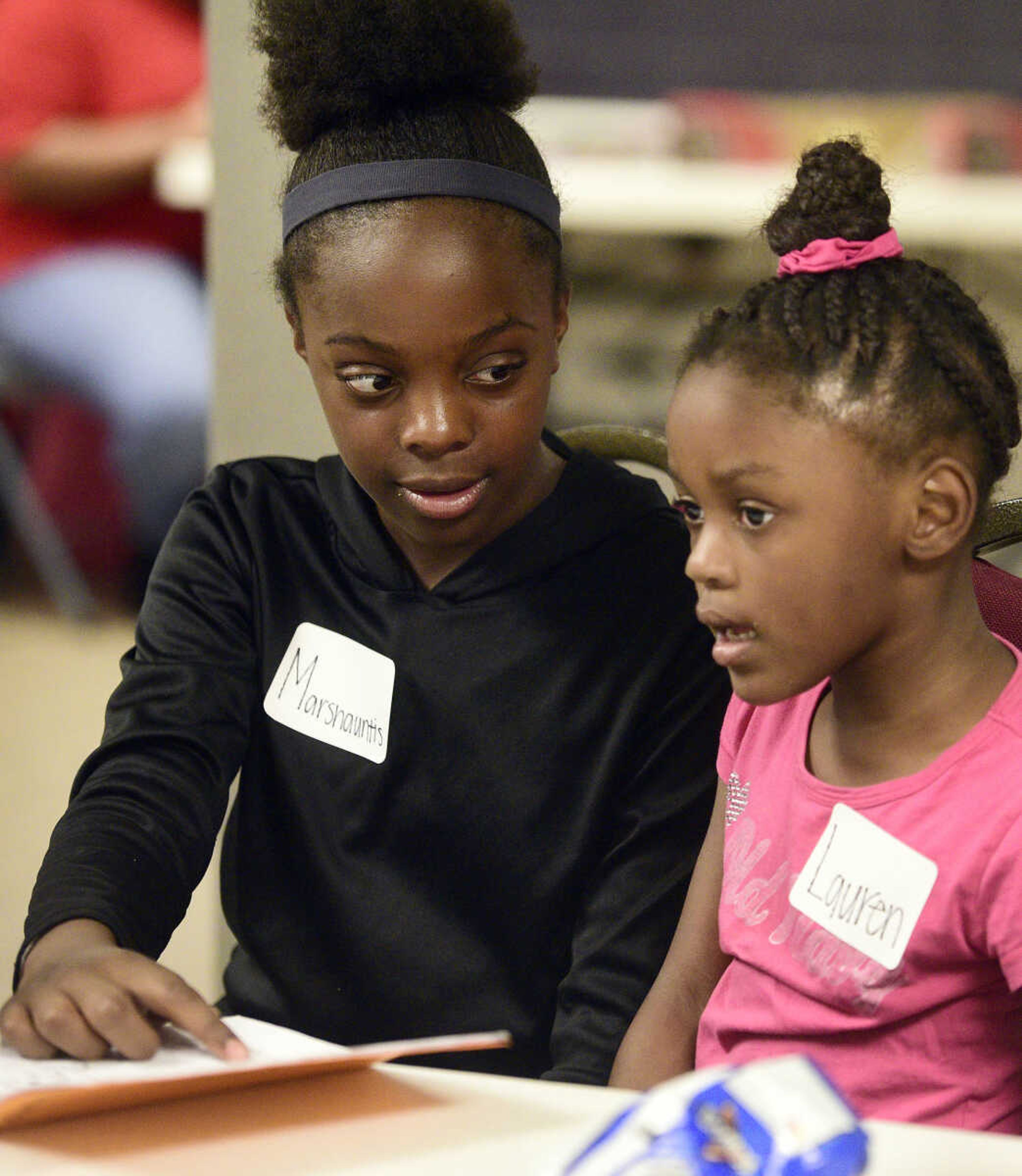 Marshauntis Washington, left, helps Lauren Washington read her book on Monday, Aug. 14, 2017, during the Salvation Army's after school program at The Bridge Outreach Center in Cape Girardeau.