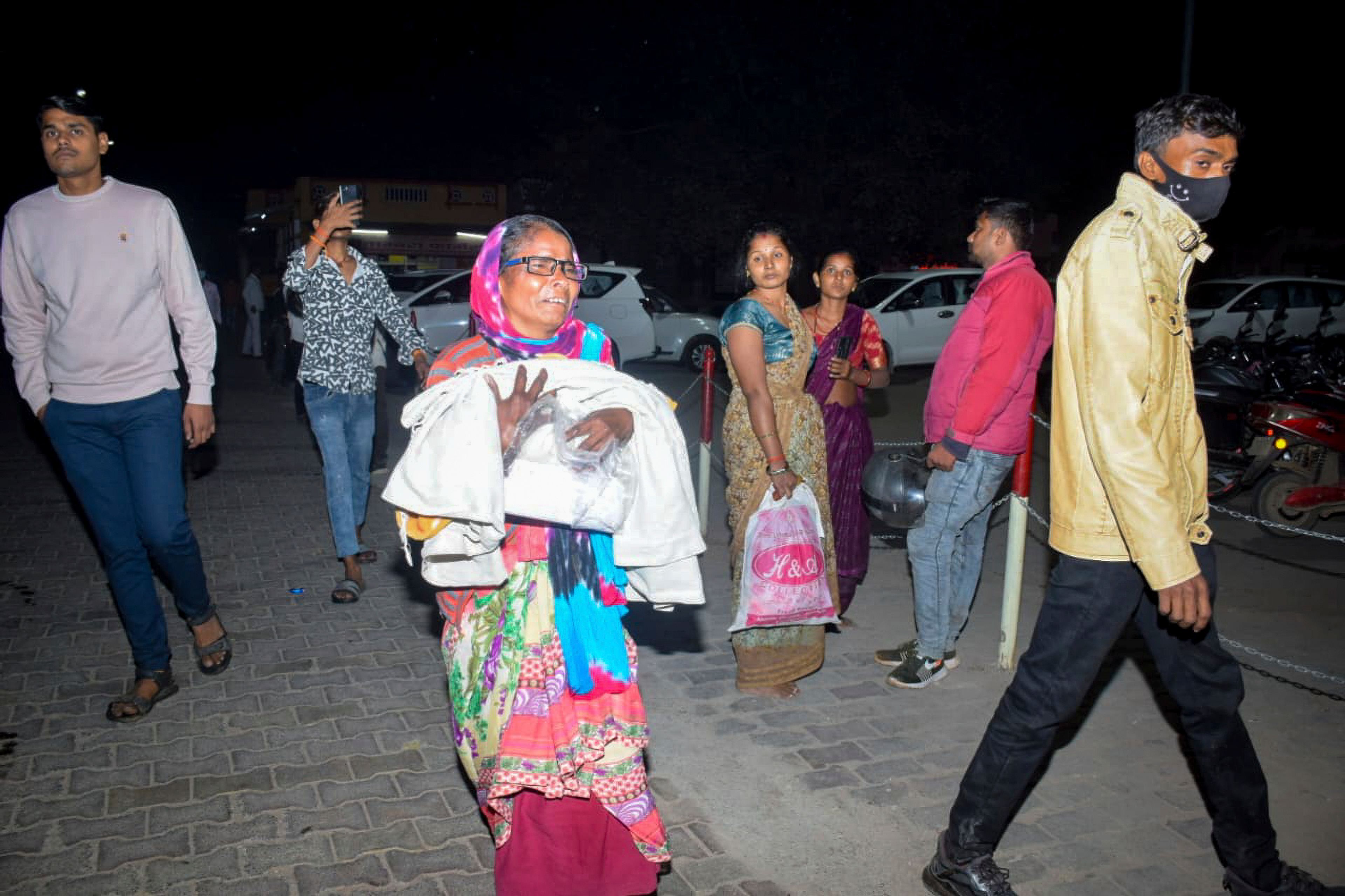 A woman rushes a child to the emergency ward after a fire broke out in a neonatal intensive care unit at Jhansi Medical College hospital in Jhansi, India, Friday, Nov. 15, 2024. (AP Photo)