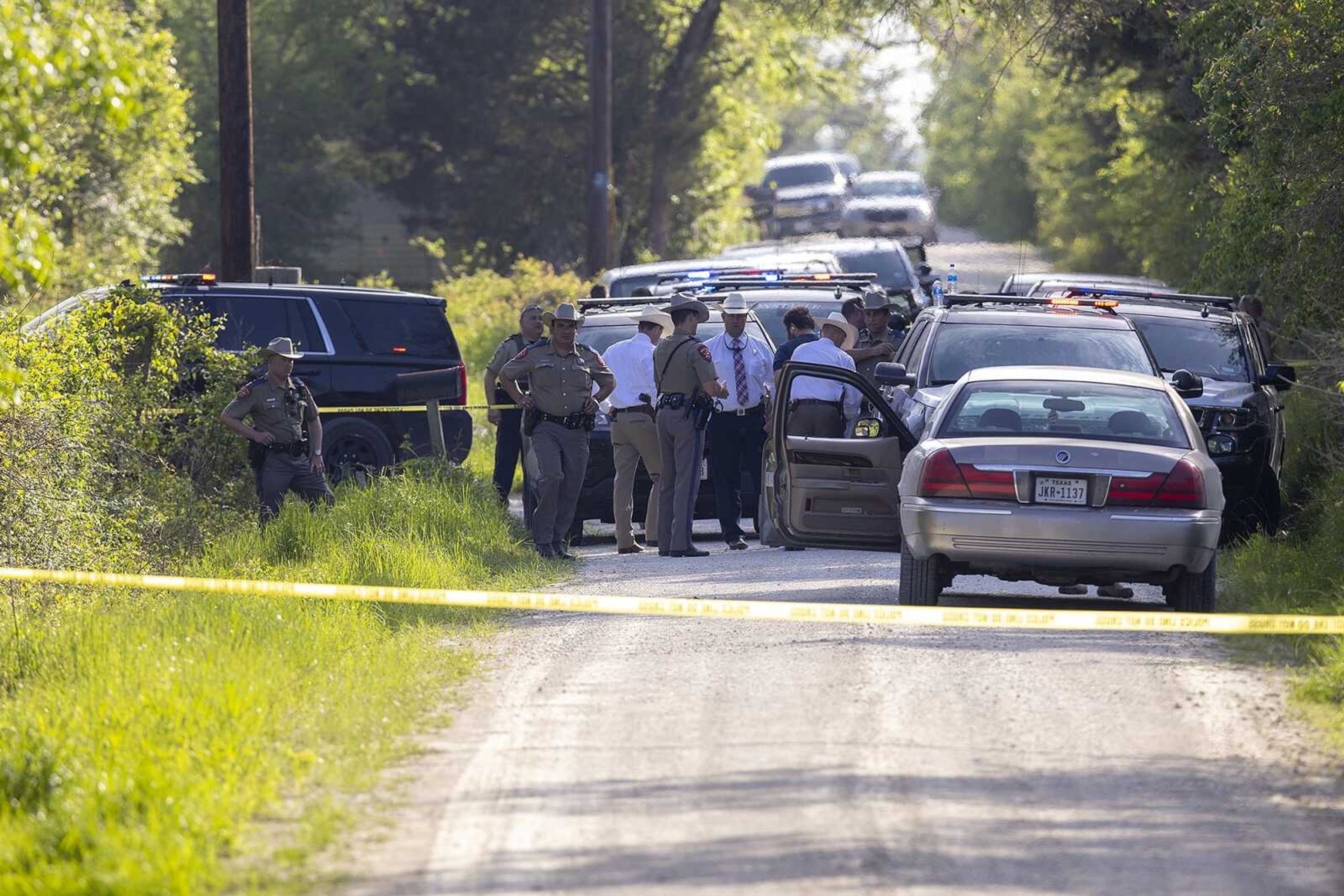 First responders work at the scene Thursday of the apprehension of a suspect at a residence in Bedias, Texas, following a shooting at Kent Moore Cabinets in Bryan, Texas. One person was killed and several people were wounded Thursday in the wake of a shooting at the cabinet-making business in Bryan, authorities said, and a state trooper was later shot during a manhunt that resulted in the suspected shooter being taken into custody.