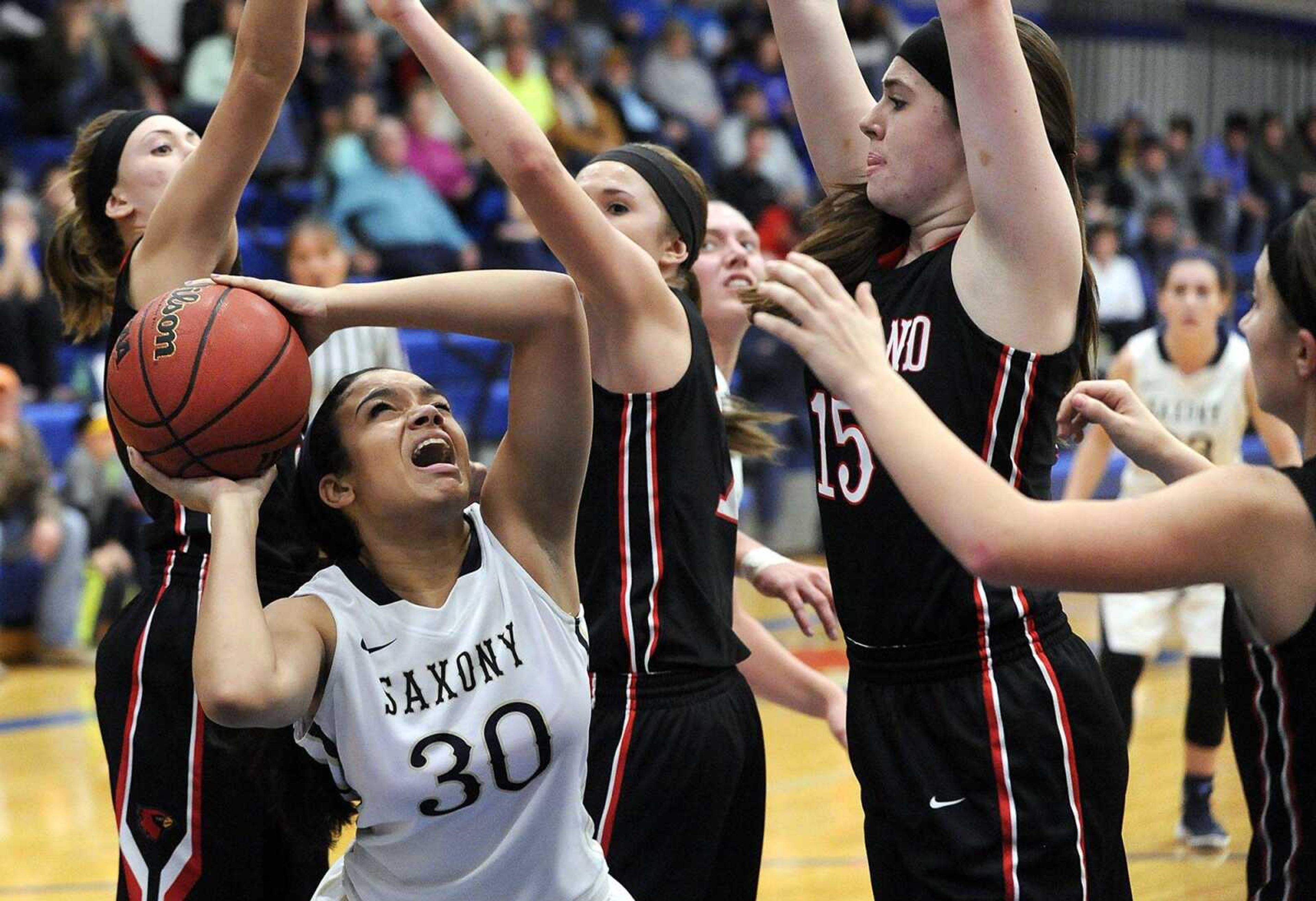 Saxony Lutheran's Masyn McWilliams tries to shoot against Woodland's Heidi Green, left, Krista Rhodes, Hannah Scott and Cheyenne Wells during the second quarter of a semifinal game in the Delta New Year's Tournament Tuesday, Jan. 5, 2016 in Delta, Missouri. (Fred Lynch)