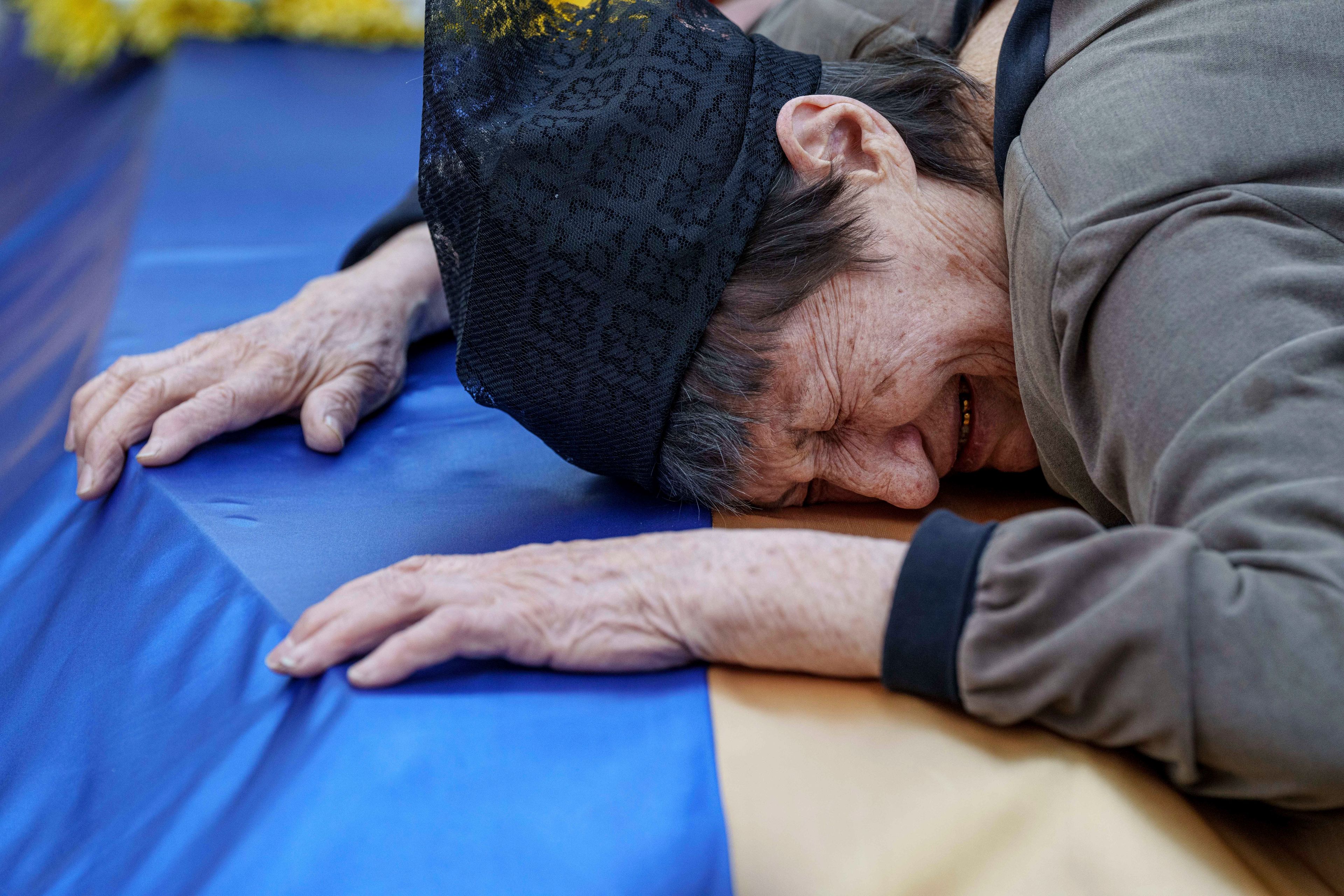 A mother cries near the coffin of her son killed in a Russian rocket attack at a Ukrainian military academy, during his funeral ceremony in Poltava, Ukraine, Saturday Sept. 7, 2024. (AP Photo/Evgeniy Maloletka)