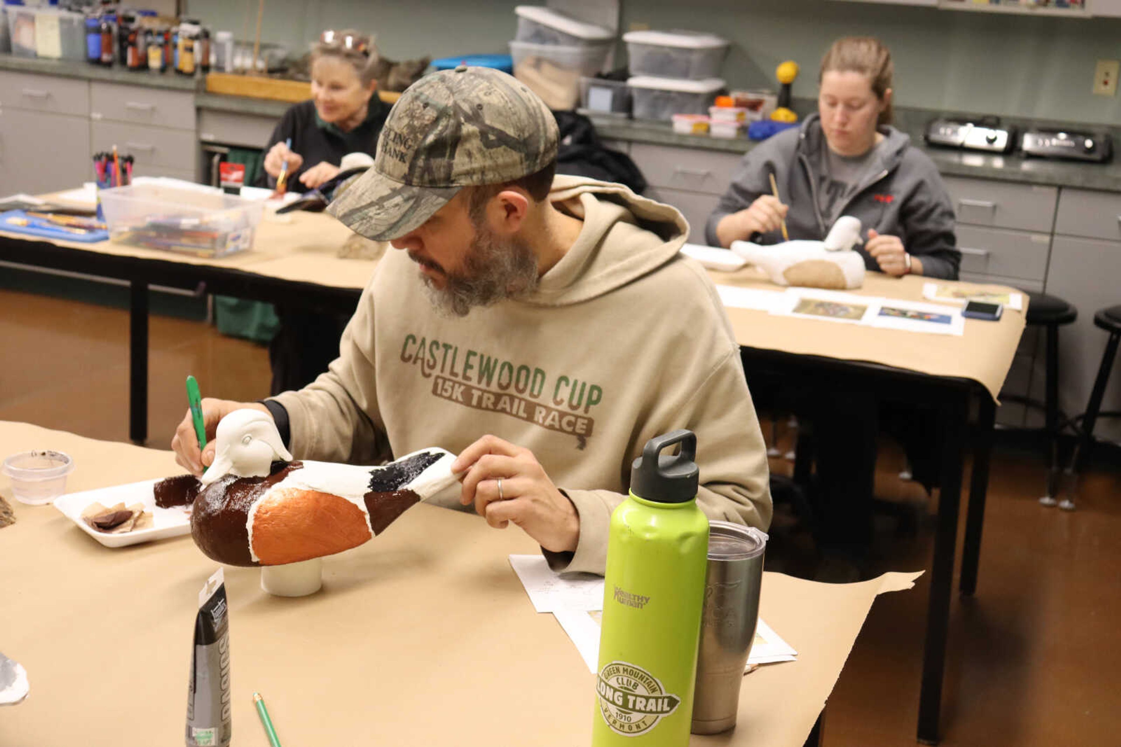 Jason Mulholland figures out which color to paint onto his decoy.