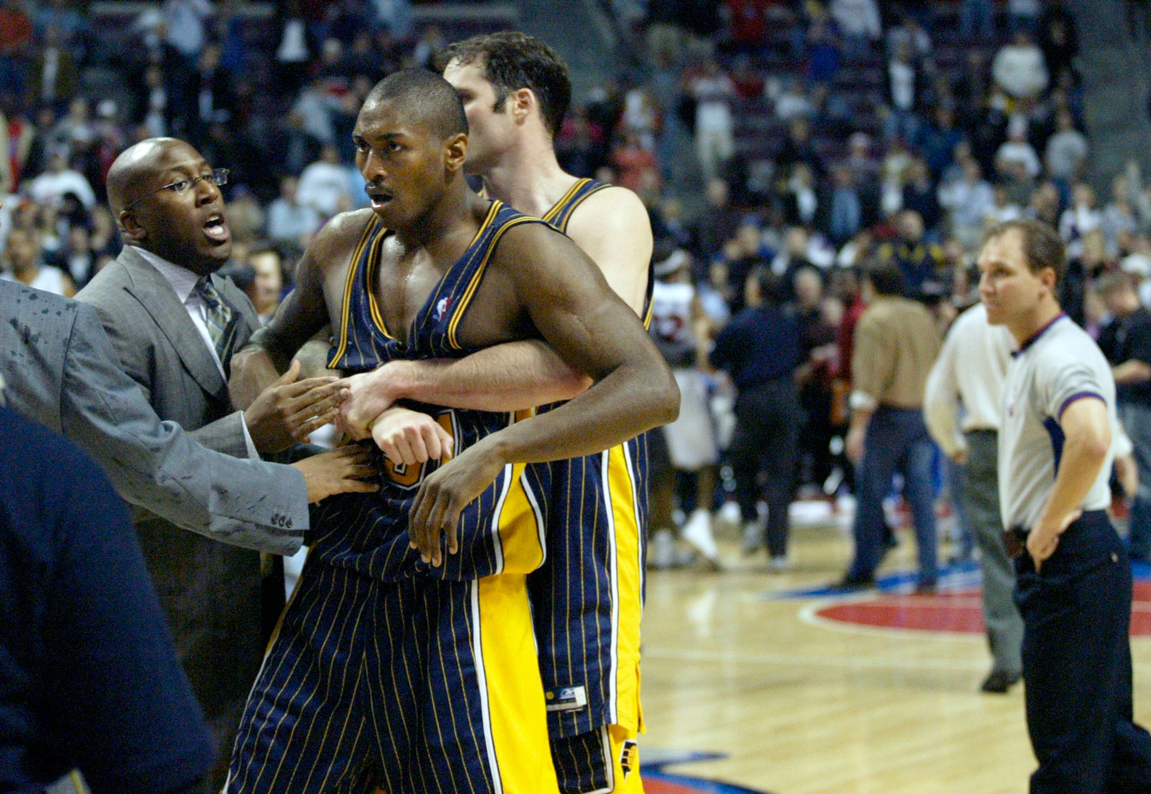 Indiana Pacers' Ron Artest is restrained before being escorted off the court following a fight with the Detroit Pistons and fans in Auburn Hills, Mich., Nov. 19, 2004. Artest and Stephen Jackson charged into the stands and fought with fans in the final minute of their game against the Detroit Pistons and the brawl forced an early end to the Pacers' 97-82 win. 