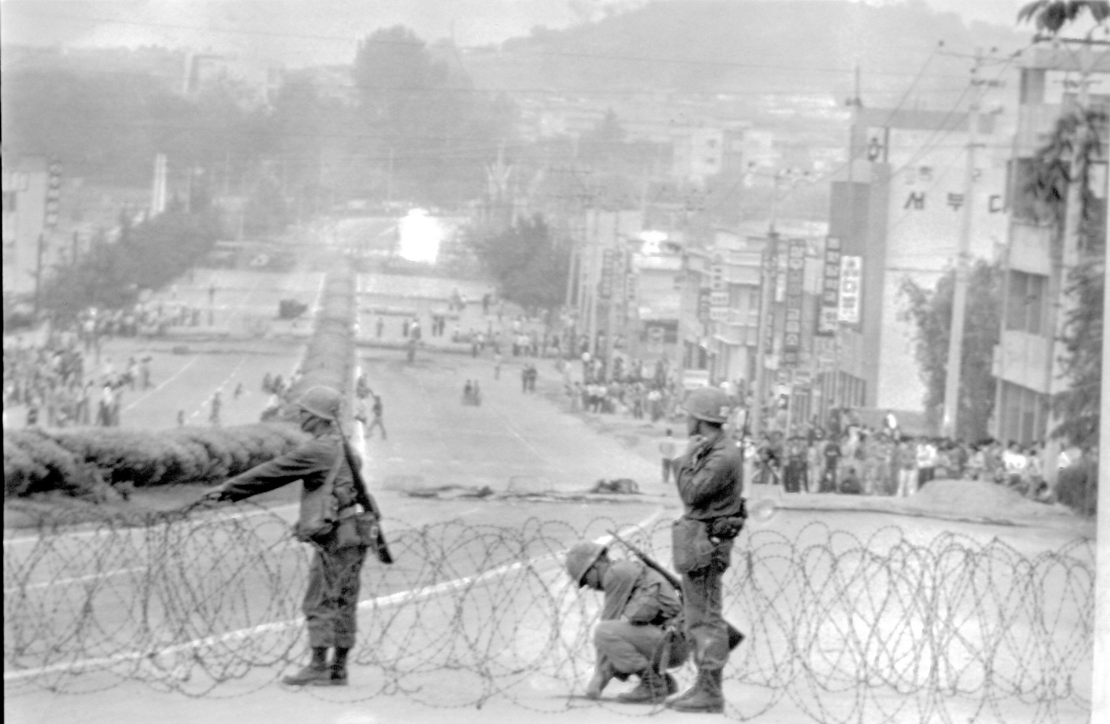 FILE- Government soldiers are erecting a roadblock on a street leading to downtown Gwangju (Kwangju), with citizens looking on, May 26, 1980. Rebels are holding the provincial capital in south western Korea days now. (AP Photo/ File)