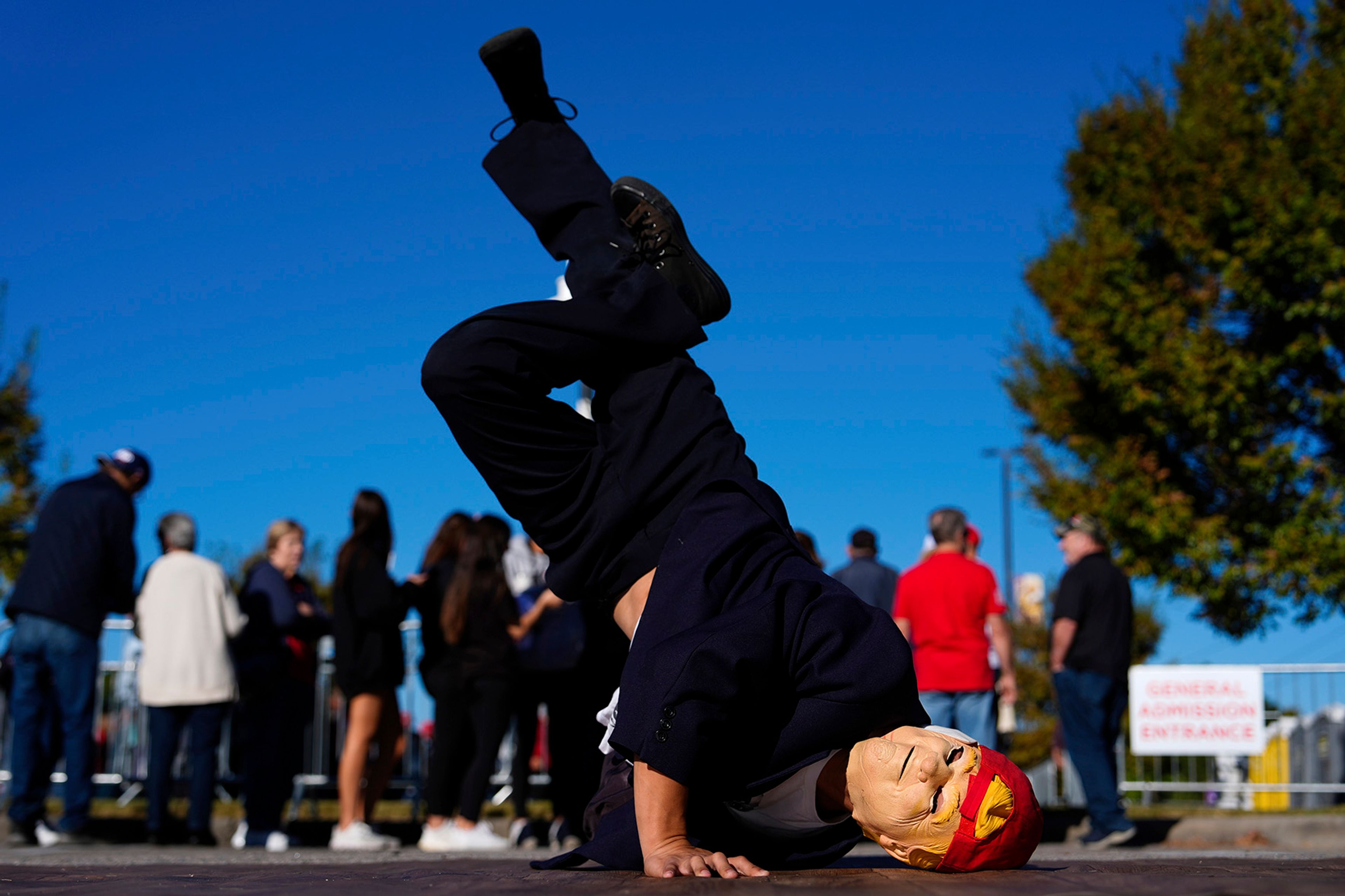 A supporter of Republican presidential nominee former President Donald Trump breakdances outside a campaign rally at Minges Coliseum, Monday, Oct. 21, 2024, in Greenville, N.C.