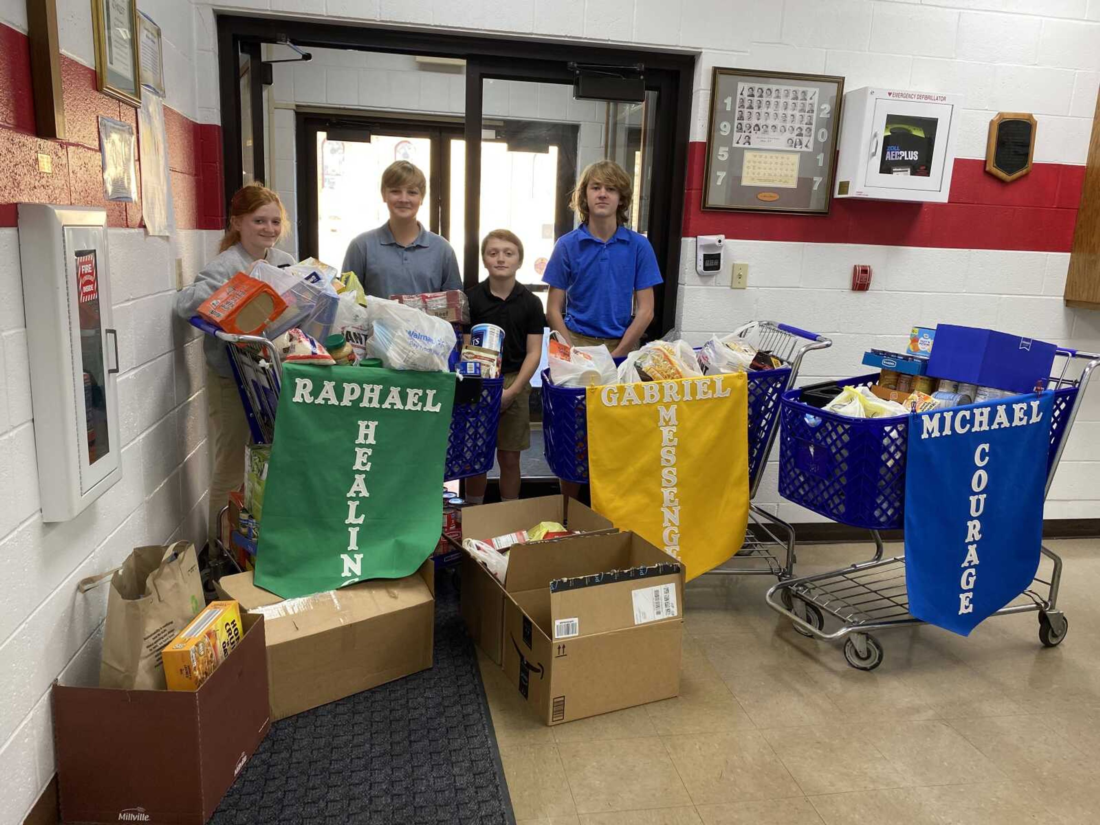 Pictured with the food drive donations are Adisyn Seabaugh, Weston Woods, Kasyn Seabaugh, and Porter Gadberry, 7th & 8th graders at Guardian Angel School.