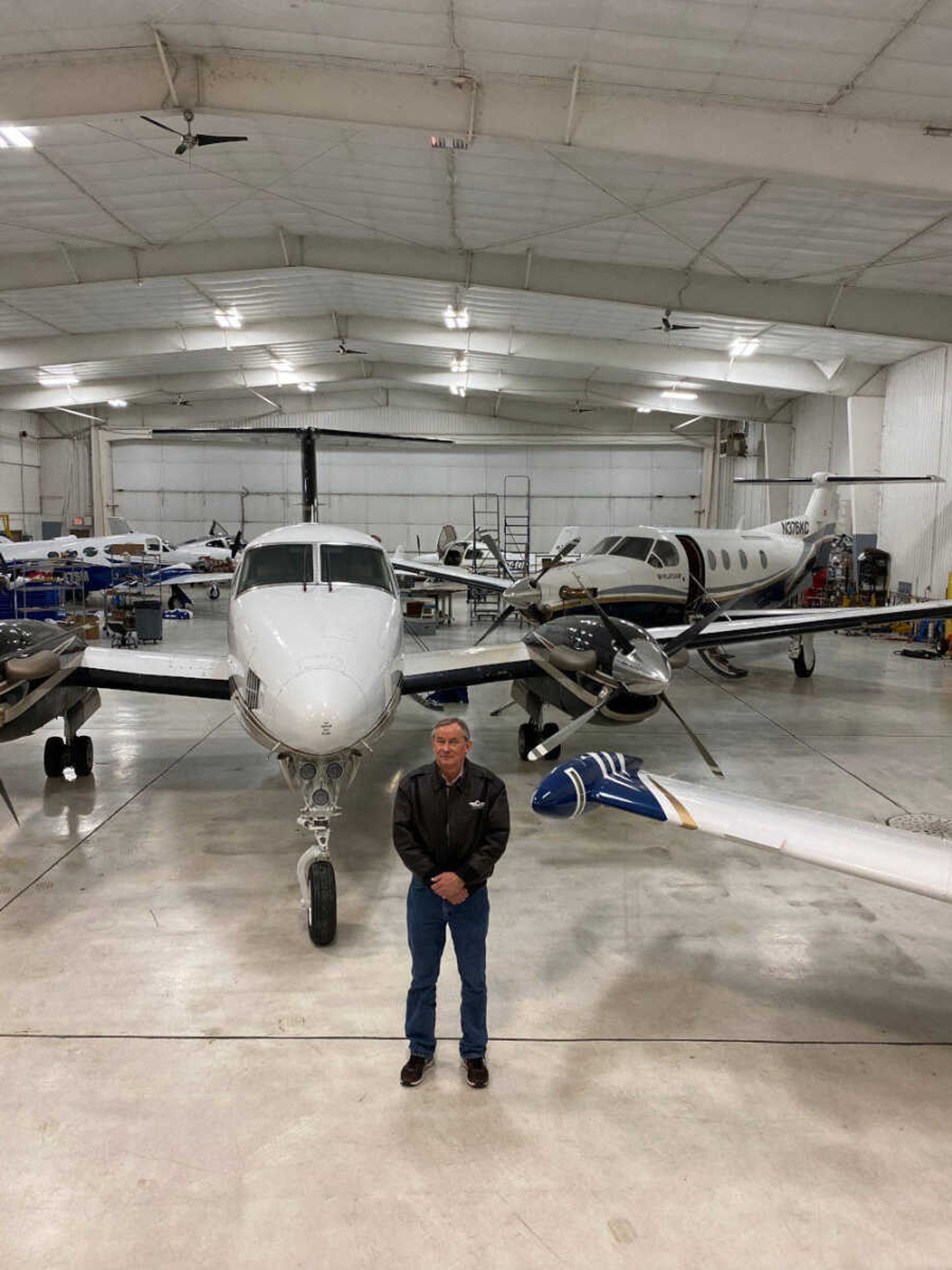 Bill Beard, owner of Cape Charter, stands in front of the multi-engine King Air 200GT and the single turboprop Pilatus PC-12.