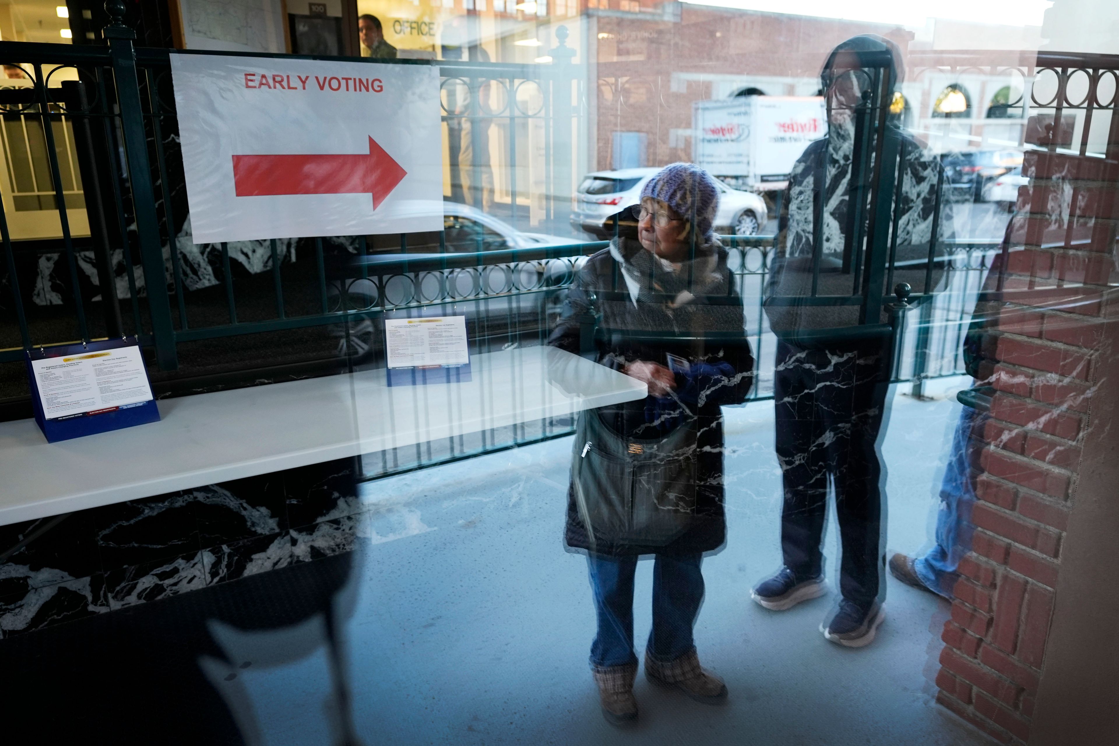 Judy Hemingson, left, of Des Moines, Iowa, waits in line for early voting at the Polk County Election Office, Wednesday, Oct. 16, 2024, in Des Moines, Iowa. (AP Photo/Charlie Neibergall)