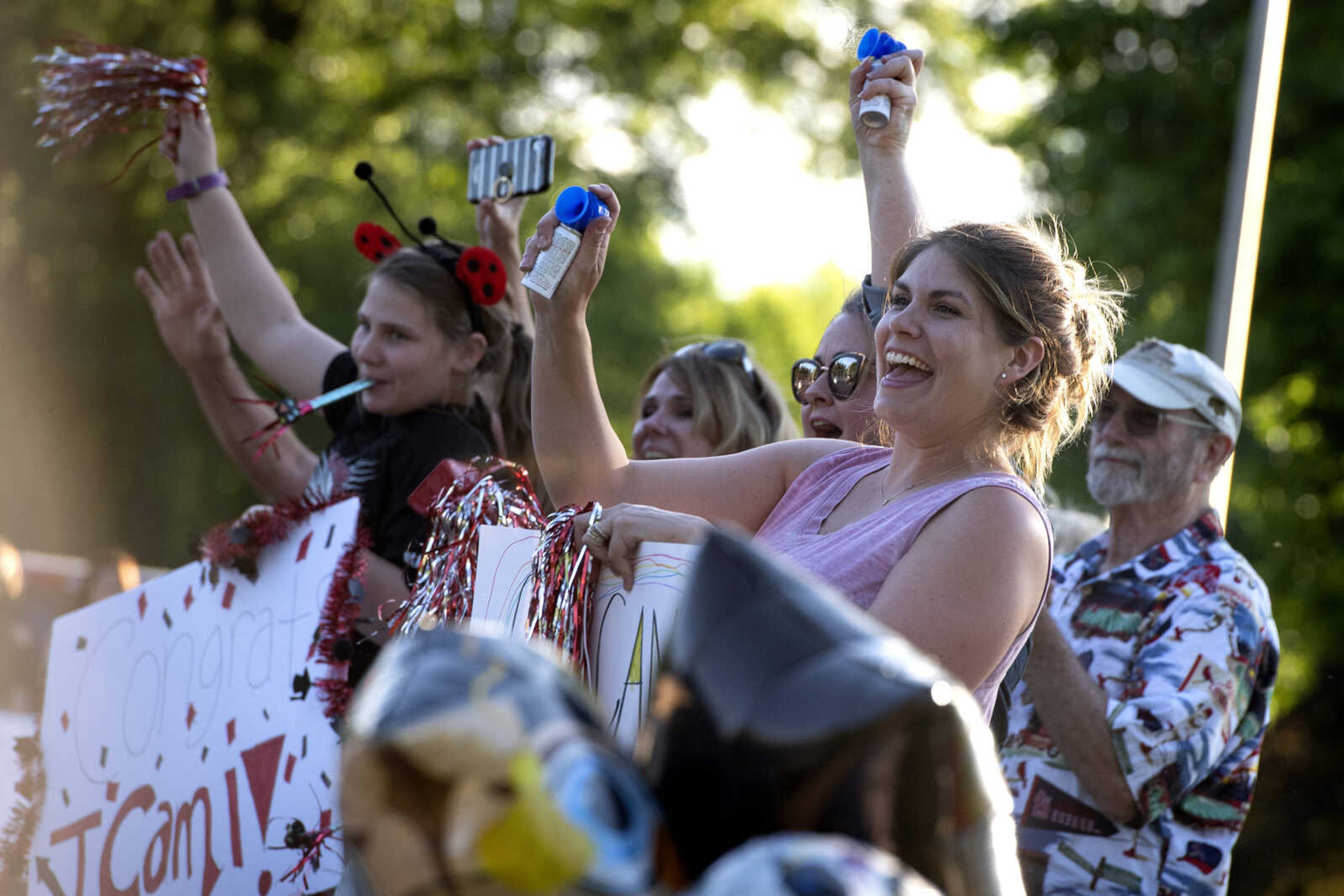 Sallie Phillips of St. Louis, Missouri, (front of frame, in pink) cheers near family during a parade for Jackson High School seniors Friday, May 29, 2020, at Jackson City Park. Phillips said she is the aunt of Jackson senior Cami Brazel. Event organizer Mendi McDowell of Jackson, mother of Jackson senior Autumn Gragg, said the event materialized after the number of people was limited at graduation. "We just wanted the safest way that we would be able to celebrate our seniors," McDowell said. She said the parade route was made long so people would have space to feel conformable. She said the parade started at the high school and went though the park before turning around and heading back to the school.