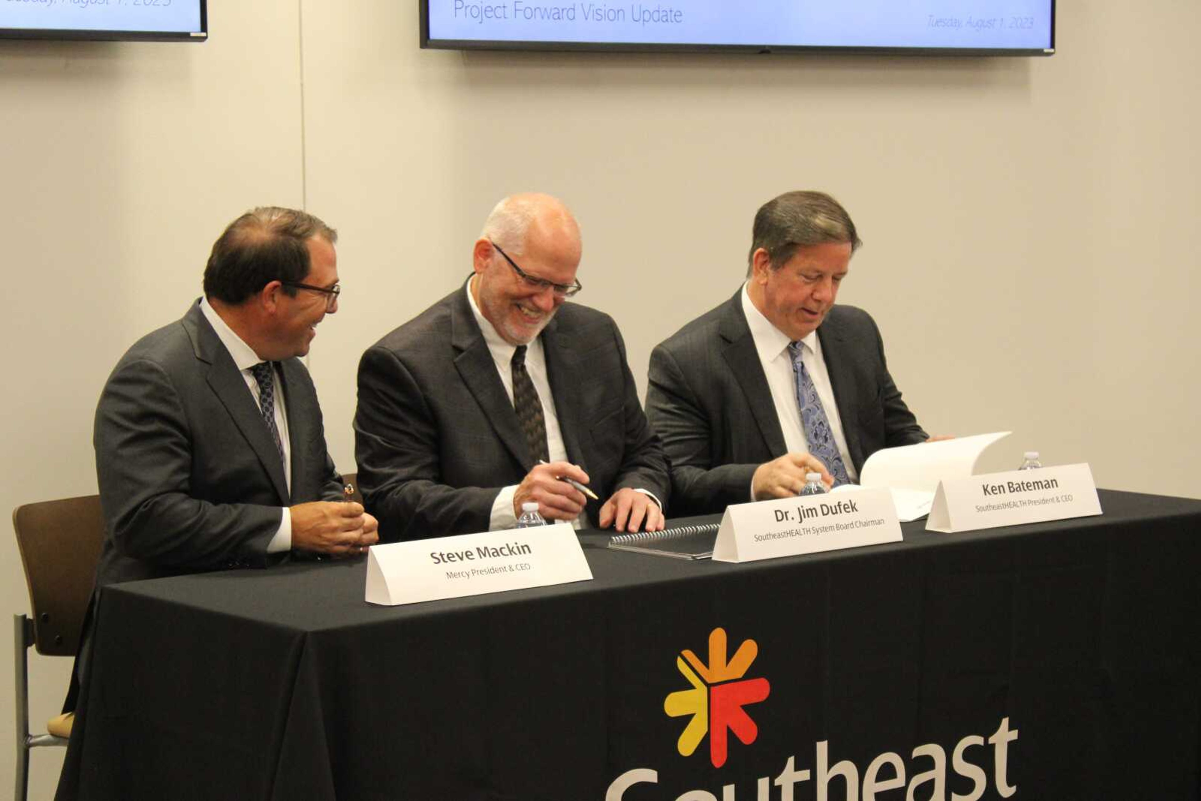 Mercy president and CEO Steve Mackin, SoutheastHEALTH system board chairman Jim Dufek and SoutheastHEALTH president and CEO Ken Bateman sign the contract Tuesday, Aug. 1, of Mercy and SoutheastHEALTH joining together.