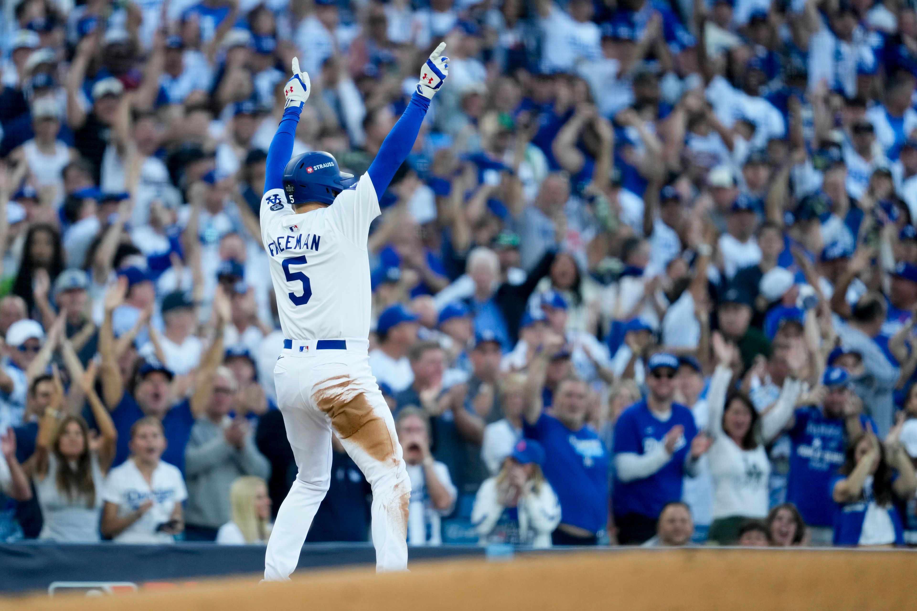 Los Angeles Dodgers' Freddie Freeman celebrates a triple against the New York Yankees during the first inning in Game 1 of the baseball World Series, Friday, Oct. 25, 2024, in Los Angeles. (AP Photo/Ashley Landis)