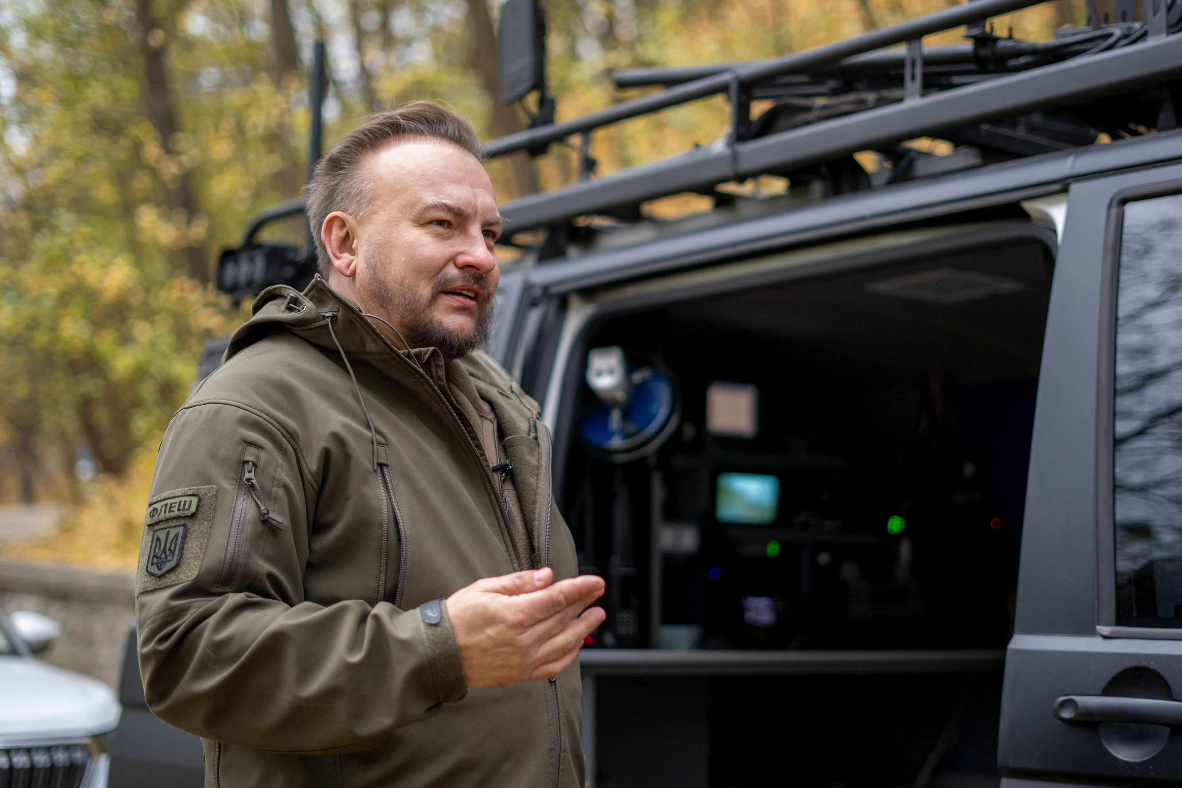 Serhii Beskrestnov, more widely known as Flash, a Ukrainian electronics expert, who hunts drones for the military, stands near his kitted-out black van in Kyiv, Ukraine, Monday, Nov. 4, 2024. (AP Photo/Hanna Arhirova)