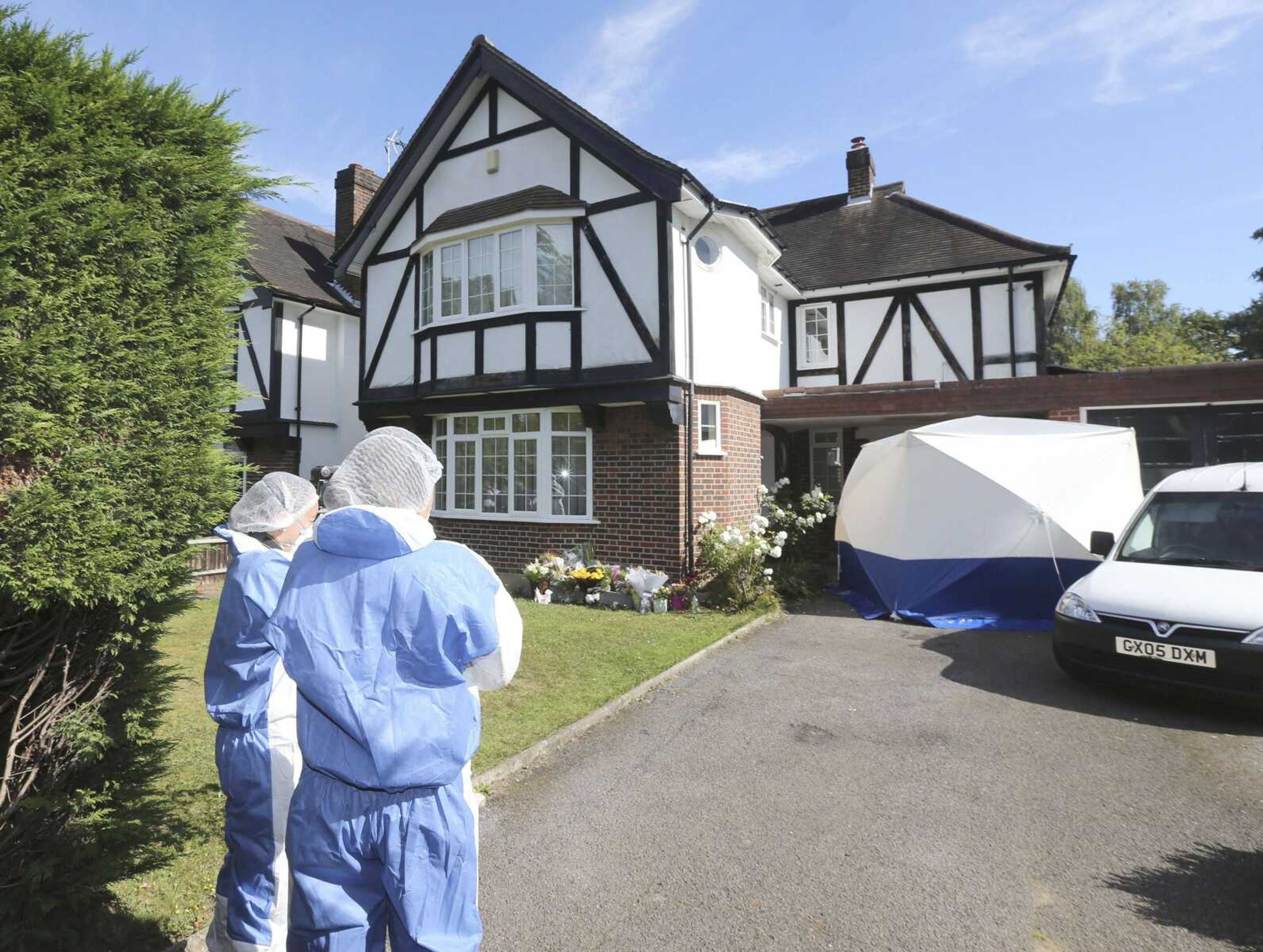 British police forensic officers stand outside the home of Saad al-Hilli on Saturday in Claygate, Britain, during investigations into the death of four people shot dead Wednesday in the French Alps. (Steve Parsons ~ Associated Press)