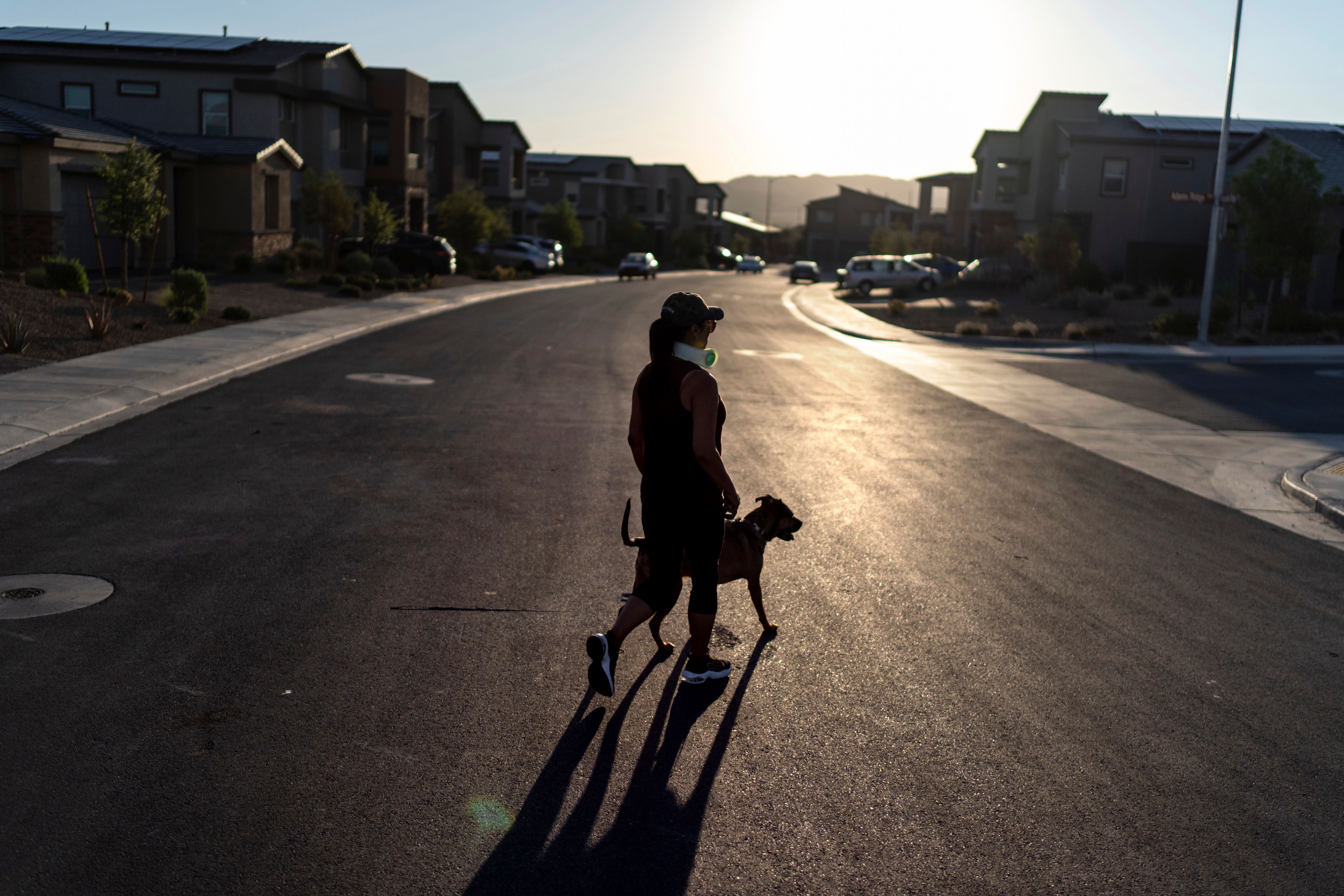 Joy Alessi walks her dog, Phoenix, through her neighborhood Tuesday, June 25, 2024, in Henderson, Nev. Alessi is one of thousands of children adopted from abroad by American parents, many of them military service members, who were left without citizenship by loopholes in American law that Congress has been aware of for decades, yet remains unwilling to fix. (AP Photo/David Goldman)