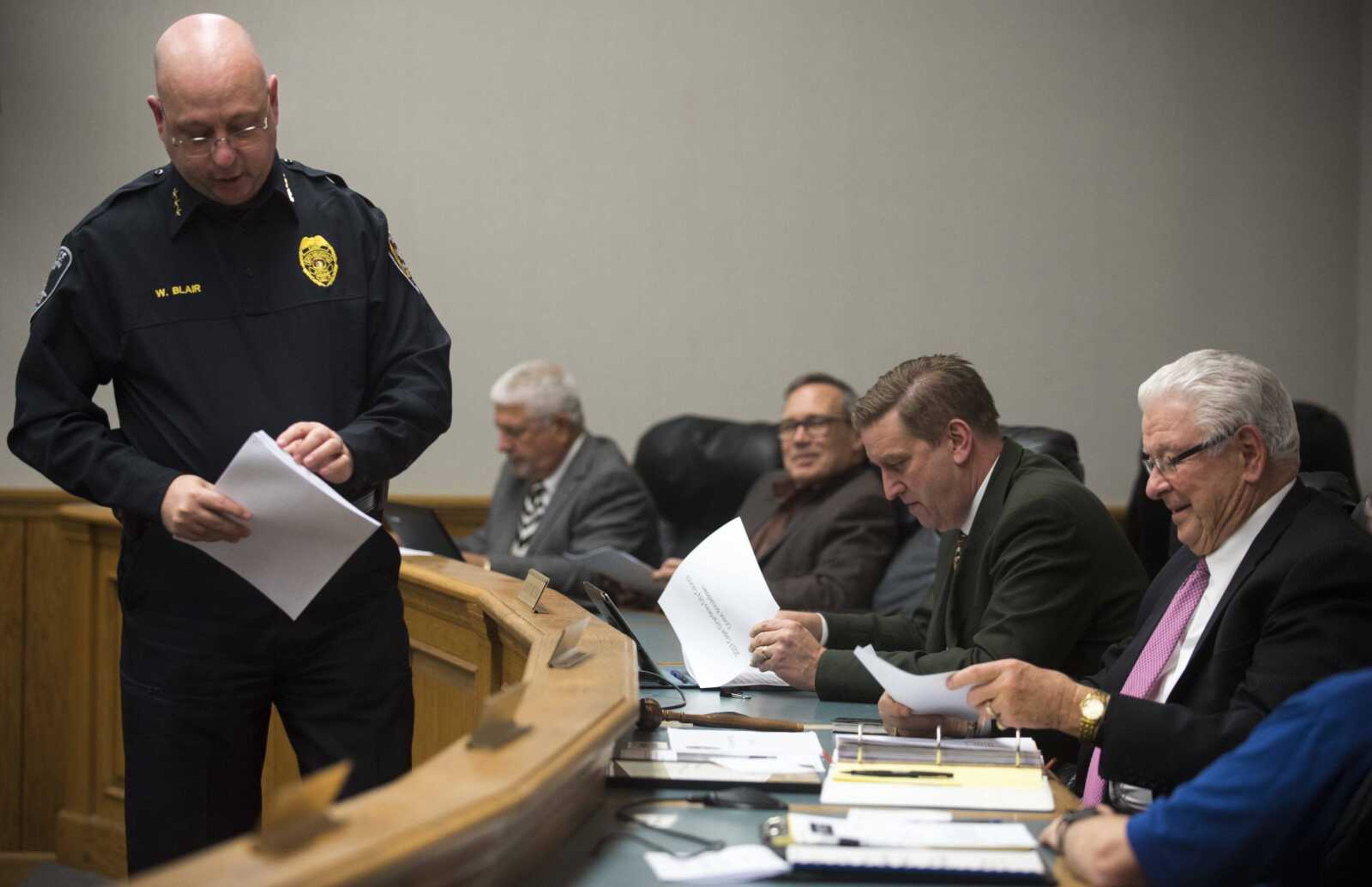 Cape Girardeau police chief Wes Blair distributes papers with information on local crime rates during a city council meeting Monday in Cape Girardeau.