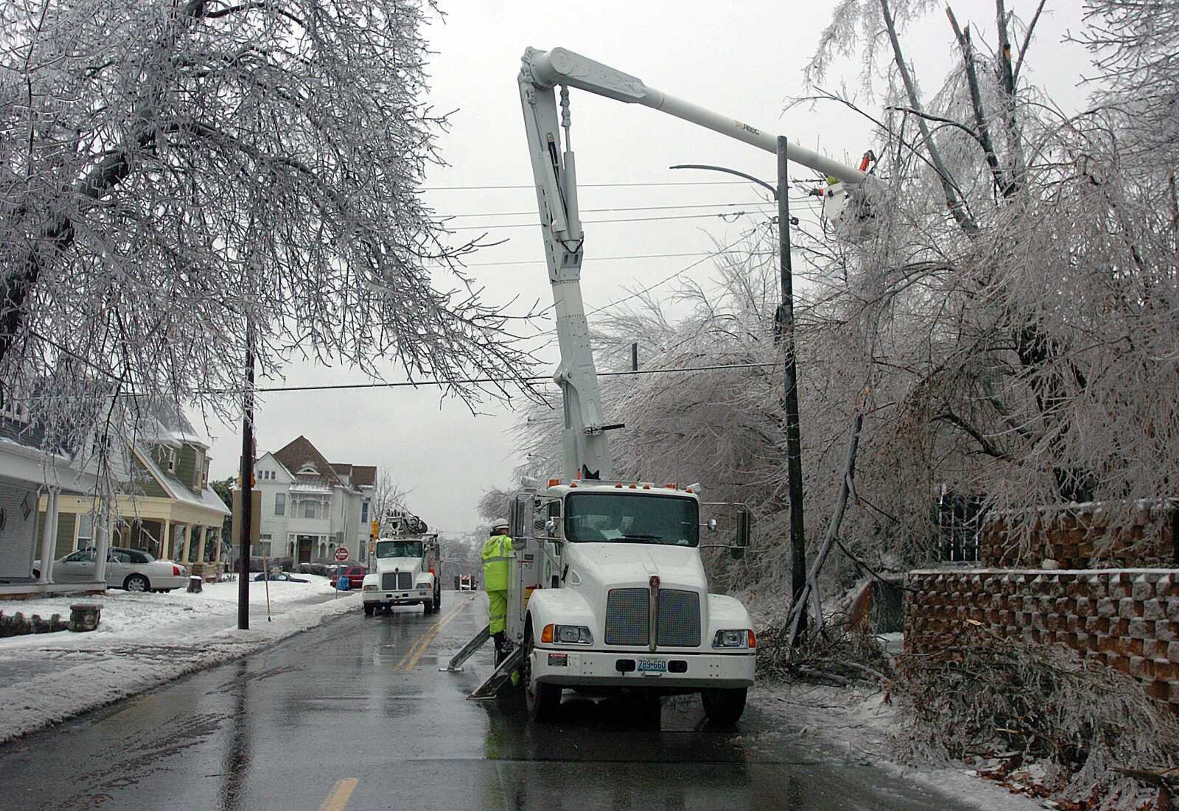 Workers restored power lines Tuesday in a St. Joseph, Mo., neighborhood. In some northeast Missouri towns, more freezing rain was adding to the layer of frozen precipitation already on the ground. (Ivan Lawhon Jr. ~ St. Joseph News-Press)