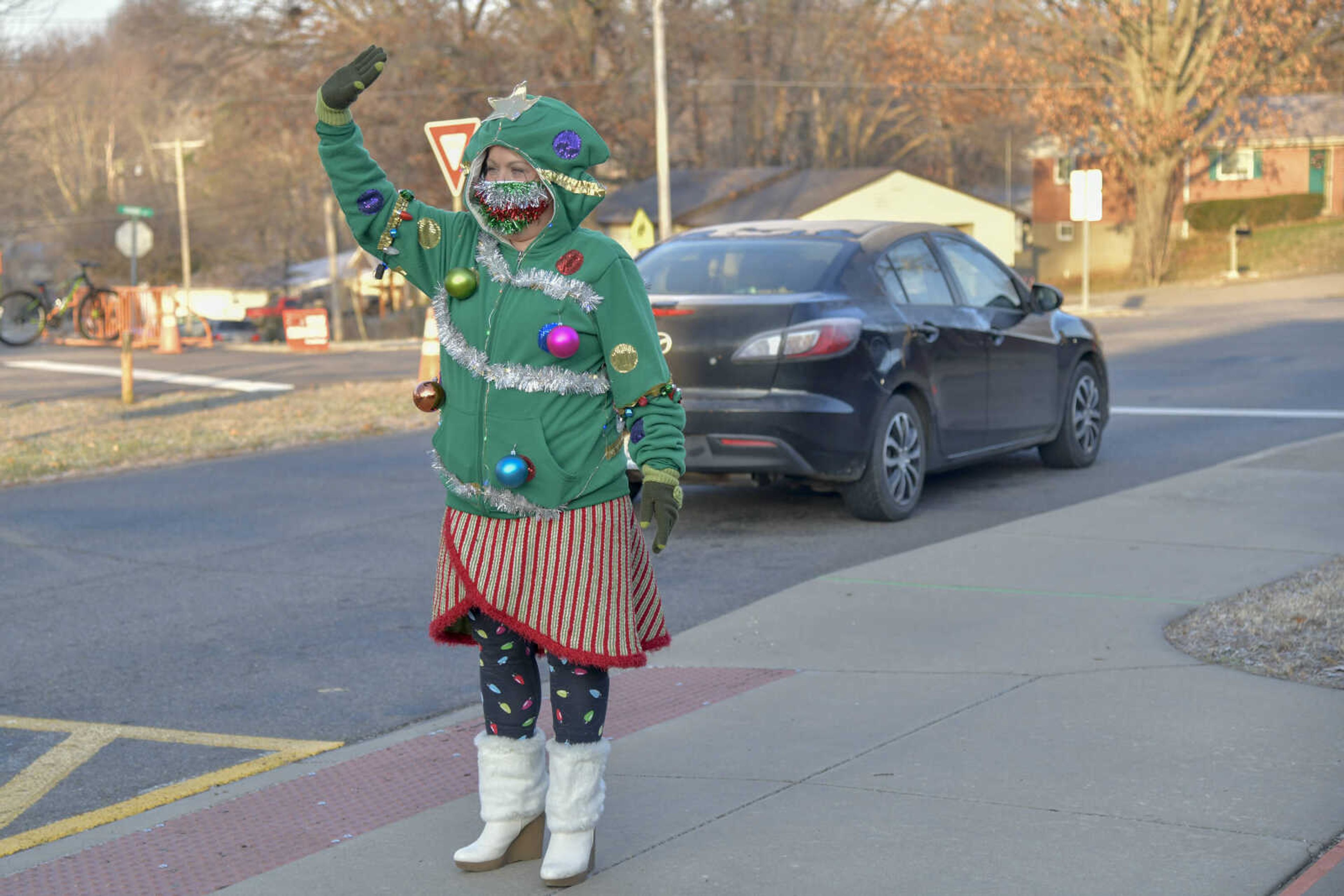 Psychological Examiner Stephanie Craft as a Christmas tree waves to students as they arrive to school at Alma Schrader Elementary School in Cape Girardeau on Thursday, Dec. 17, 2020.