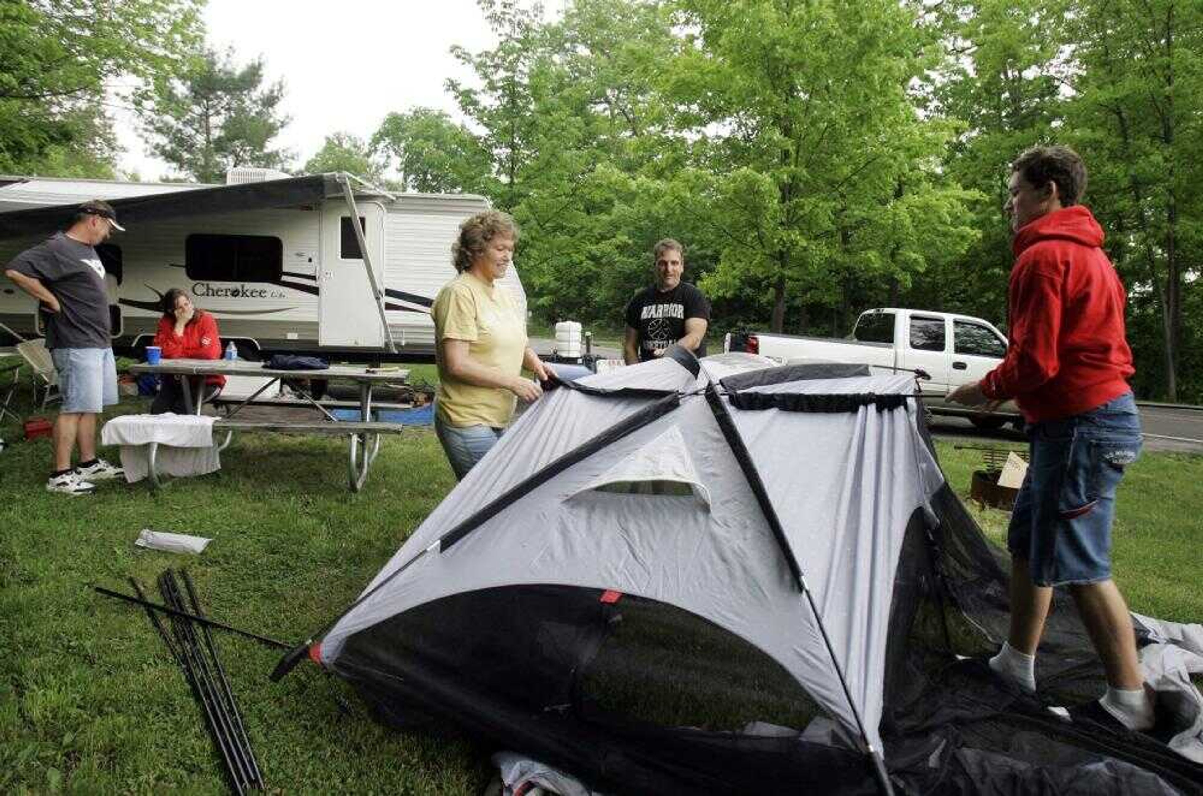 Vickie Steiner, and her husband, Del, and her son, Nathan, set up a tent Friday at Punderson State Park in Newbury, Ohio. The Steiners usually drive two hours away on this holiday weekend, but because of the gas prices they decided to stay closer to home. They live about 30 minutes away in Garretsville, Ohio. (TONY DEJAK ~ Associated Press)