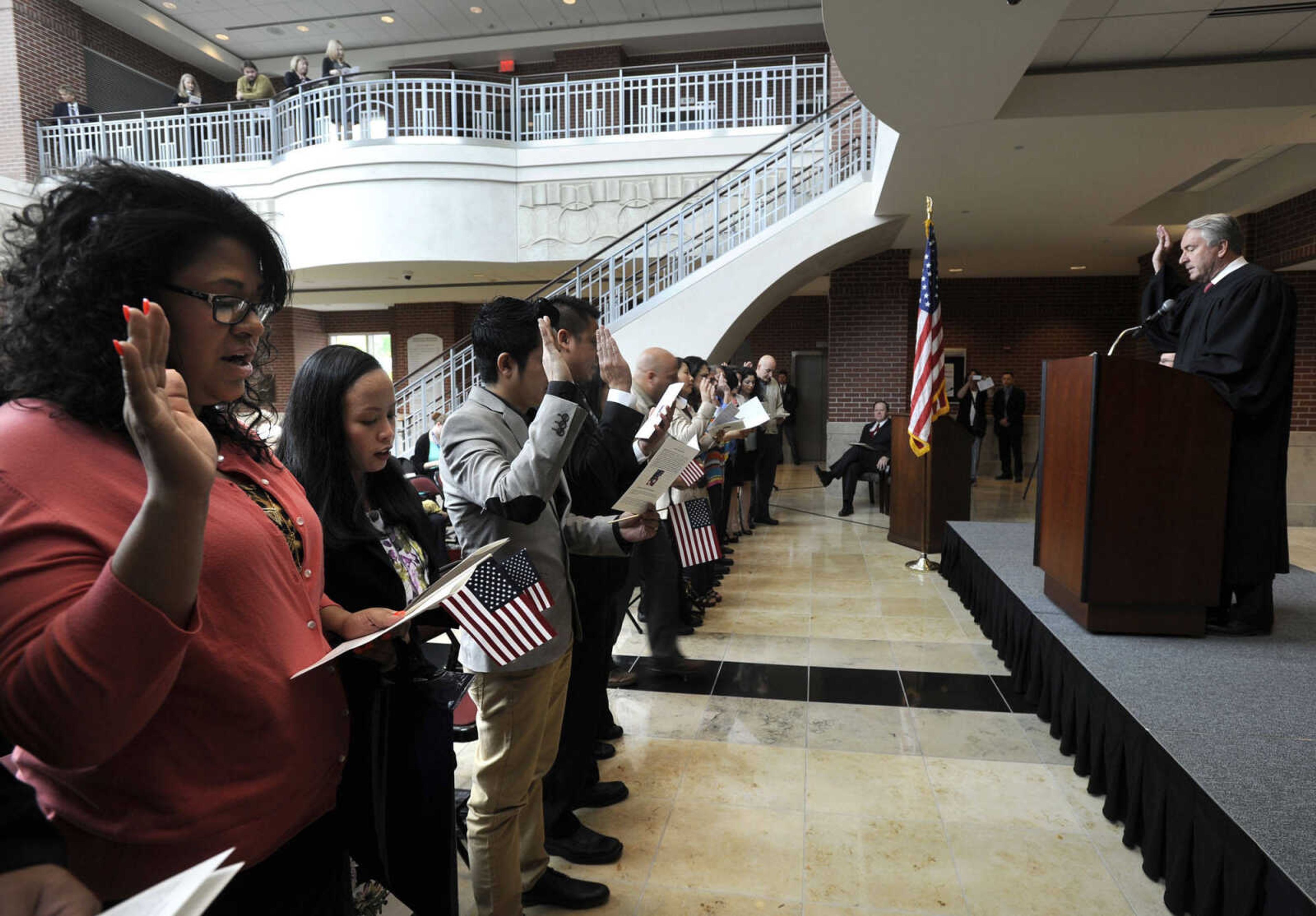 U.S. District Judge Stephen N. Limbaugh Jr. administers the Naturalization Oath of Allegiance to the United States to petitioners during a naturalization ceremony Friday, May 2, 2014 at the Rush H. Limbaugh Sr. U.S. Courthouse in Cape Girardeau.