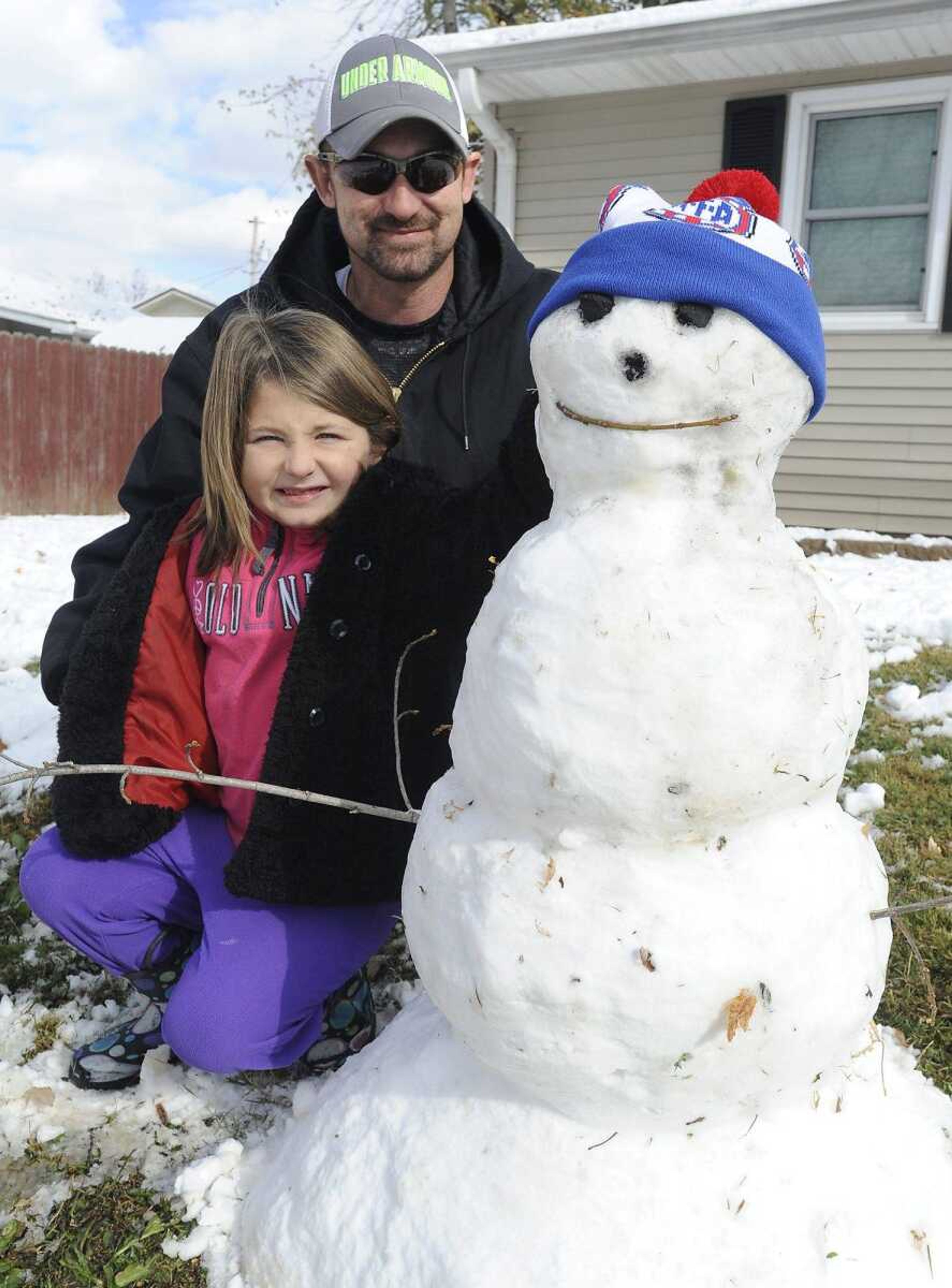 With school canceled for snow in Scott City, Alexis Perkey and her father, Jerry Perkey, knew what they had to do. Make a snowman. "We do one every time it snows," he said, as they posed with the finished product Monday outside their home. (Fred Lynch)