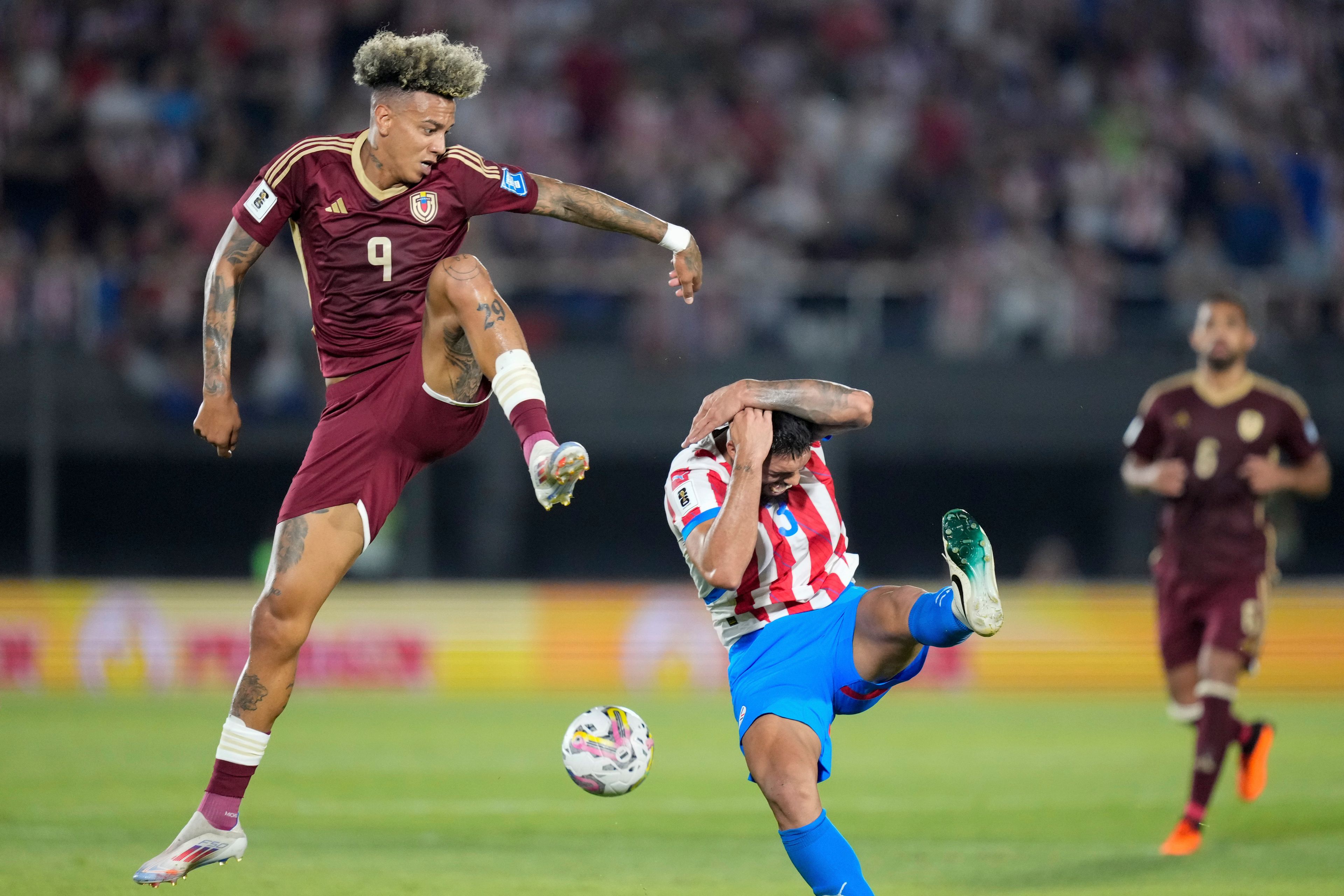 Venezuela's Jhonder Cadiz, left, and Paraguay's Omar Alderete vie for the ball during a FIFA World Cup 2026 qualifying soccer match at Defensores del Chaco Stadium in Asuncion, Paraguay, Oct. 15, 2024. (AP Photo/Jorge Saenz)