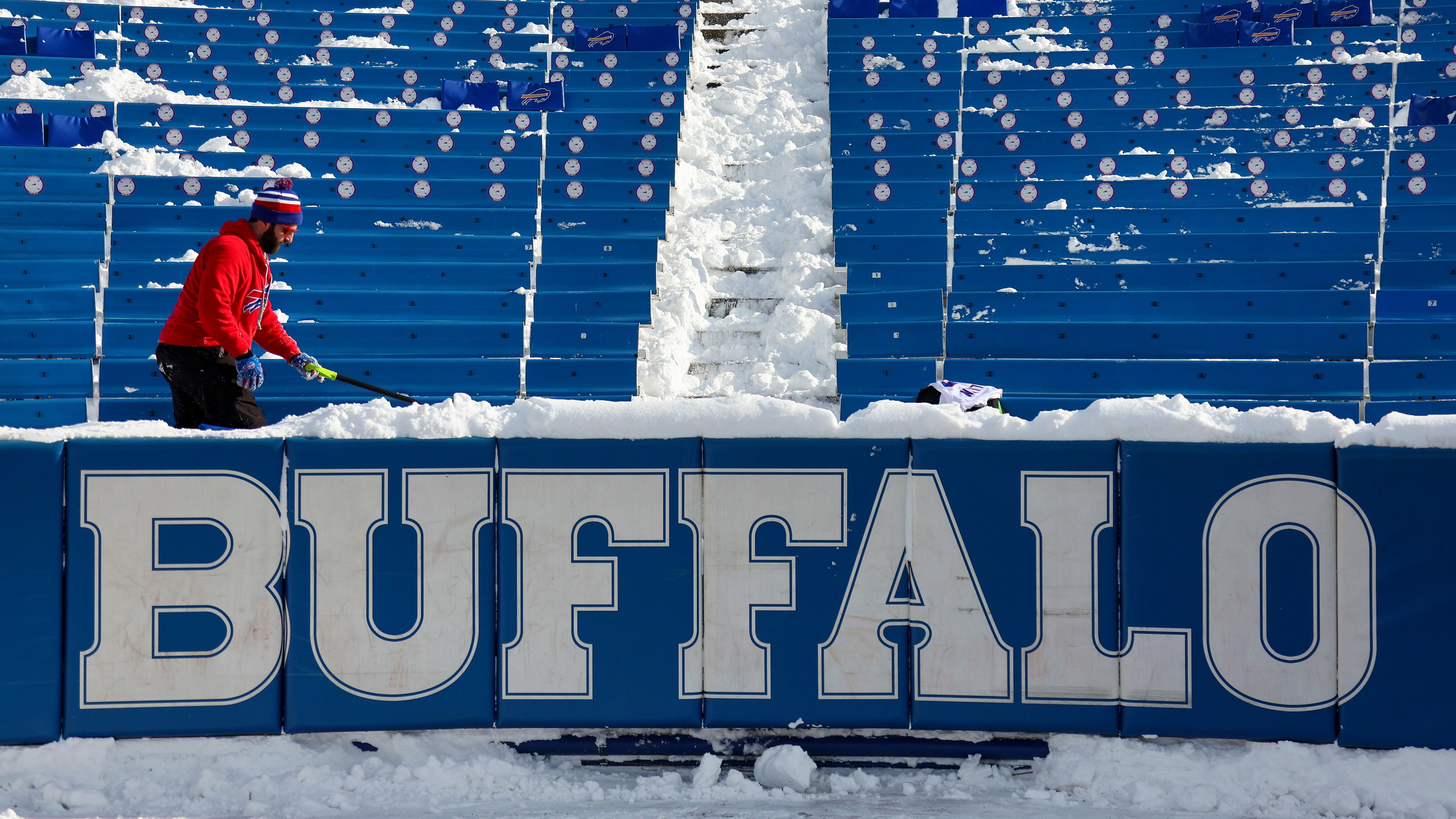 FILE - A stadium worker clears snow from seats before an NFL wild-card playoff football game between the Buffalo Bills and the Pittsburgh Steelers, Monday, Jan. 15, 2024, in Buffalo, N.Y. (AP Photo/Jeffrey T. Barnes, File)